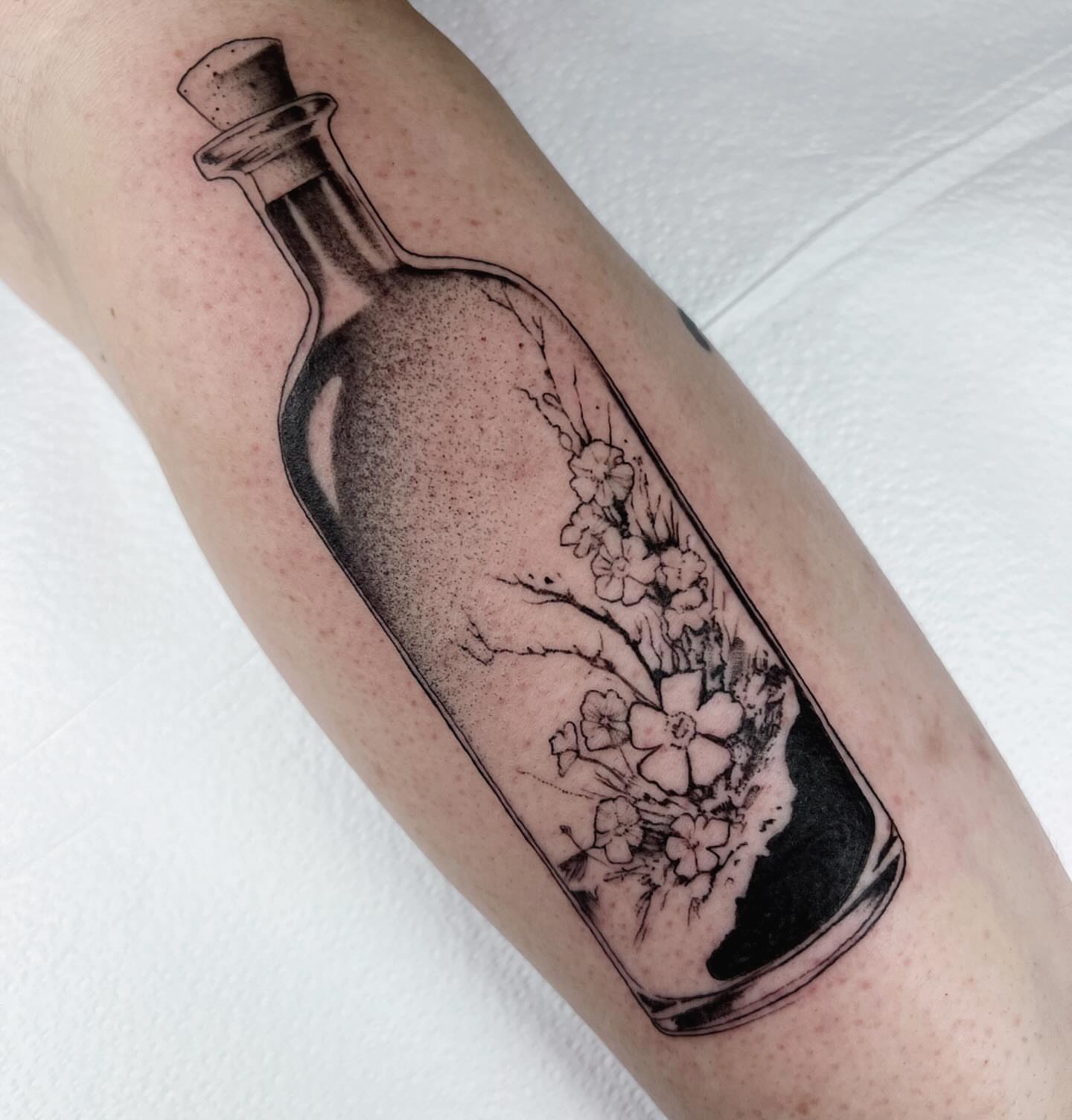 Bottle with flowers dotwork tattoo on the forearm by Anna Wolff, Richmond, Virginia