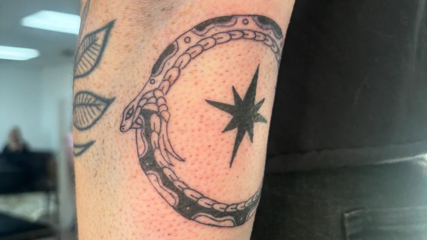 Snake and star dotwork tattoo on the forearm by Mickey