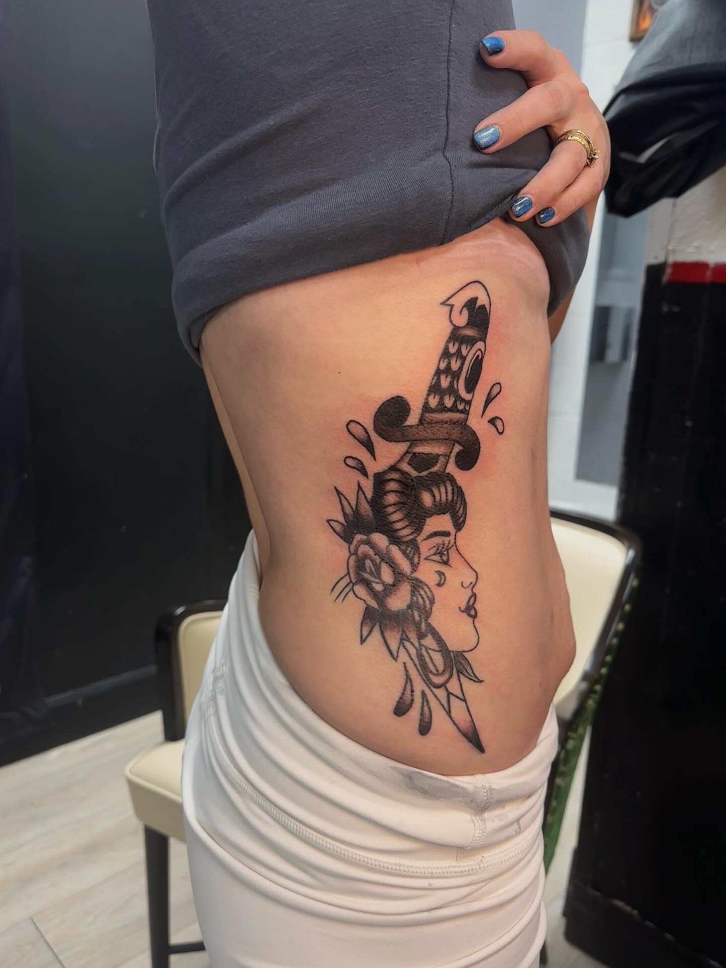 Woman with dagger American traditional tattoo on the ribs by Cherry Tats🍒