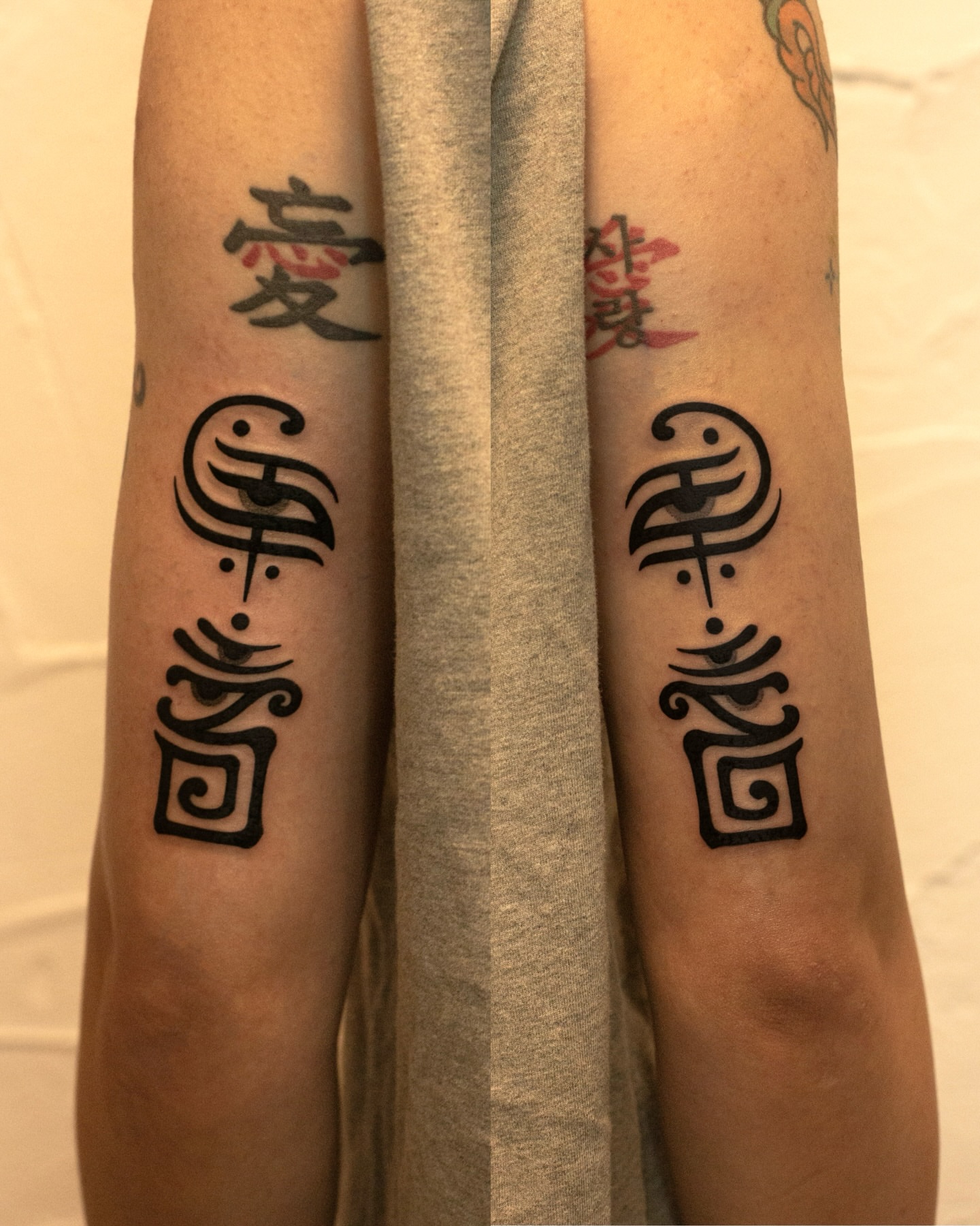 Kanji characters black and grey tattoo on the forearm by Fisher Man