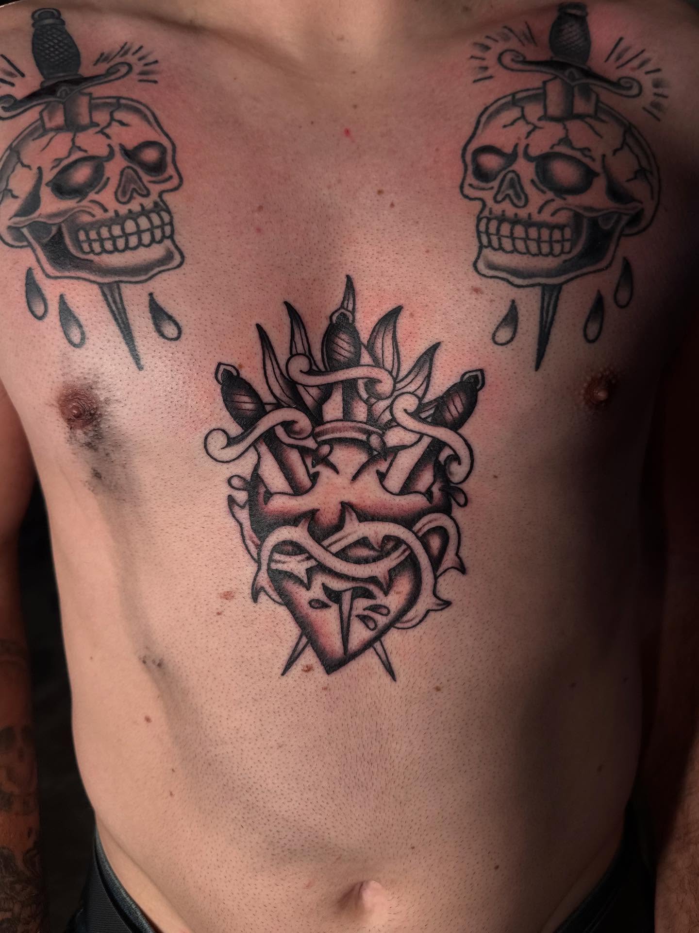 Heart with swords black and grey tattoo on the chest by frankie quadrini