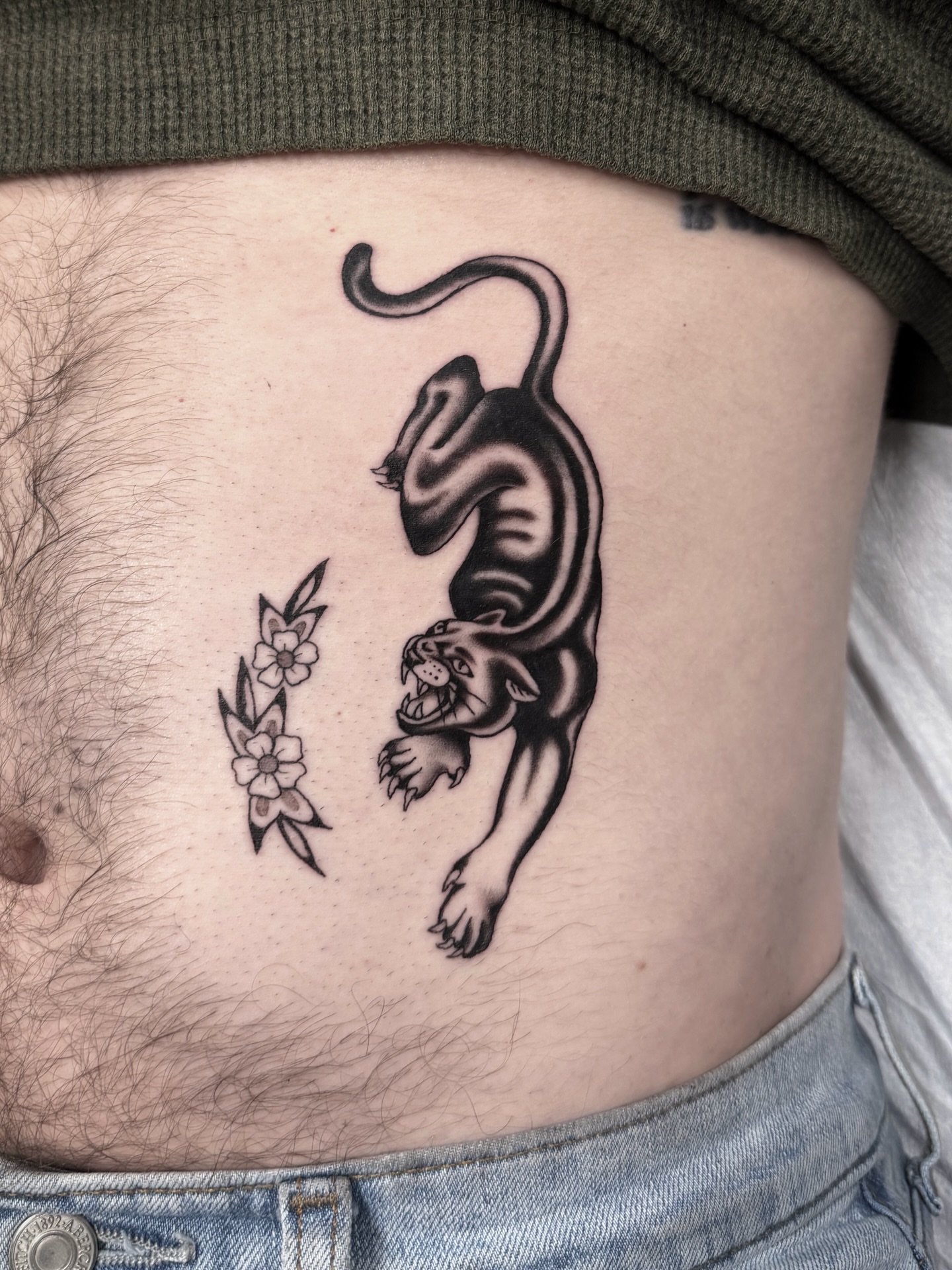 Panther and flowers black and grey tattoo on the ribs by Nicholas Lee, San Francisco, California