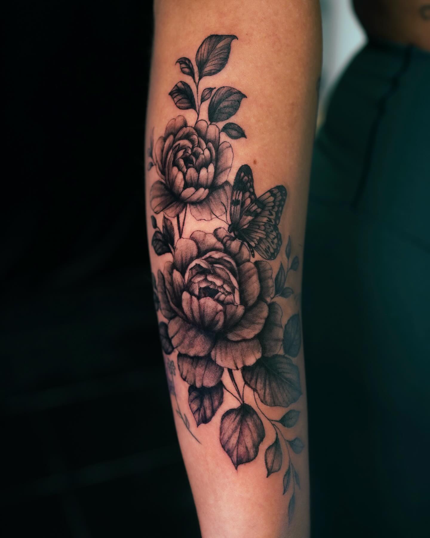 Peonies and butterfly black and grey tattoo on the forearm by Rachel