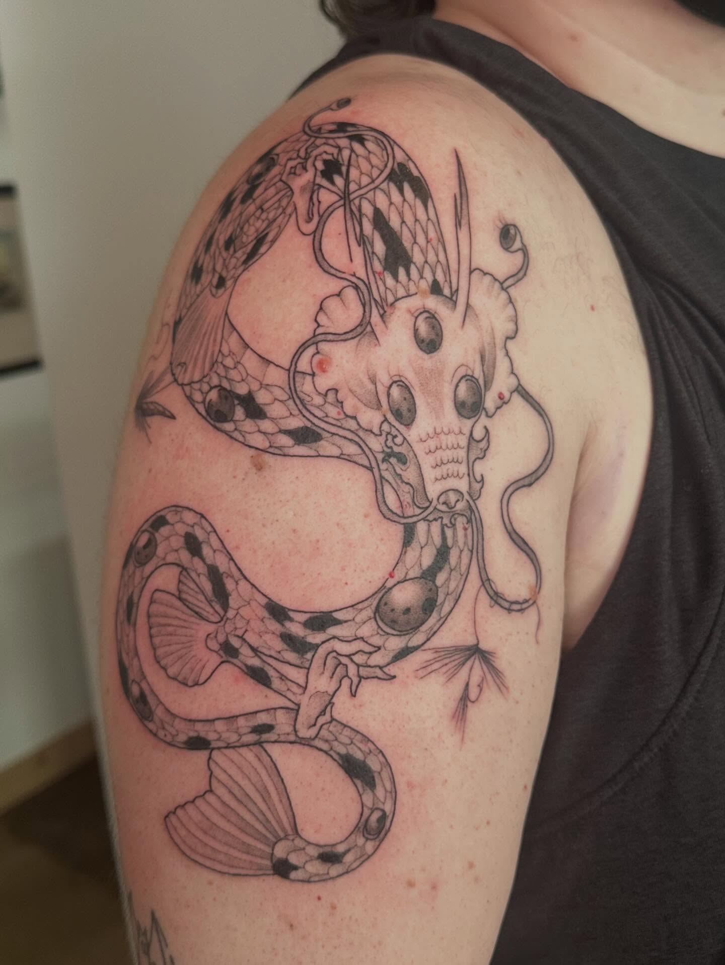 Snake black and grey tattoo on the shoulder by Nia Malone (Knee-Uh)