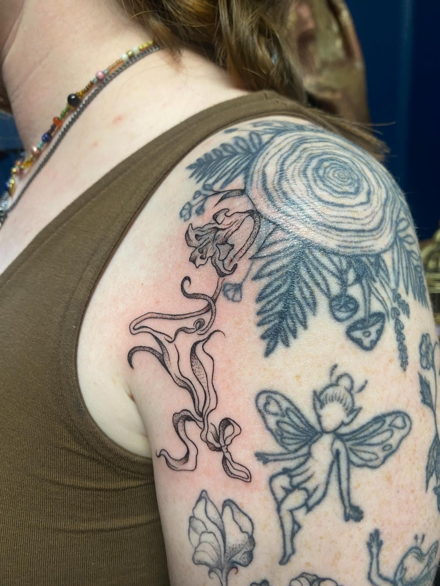 Fairy and floral black and grey tattoo on the shoulder by Jesikah Rapp