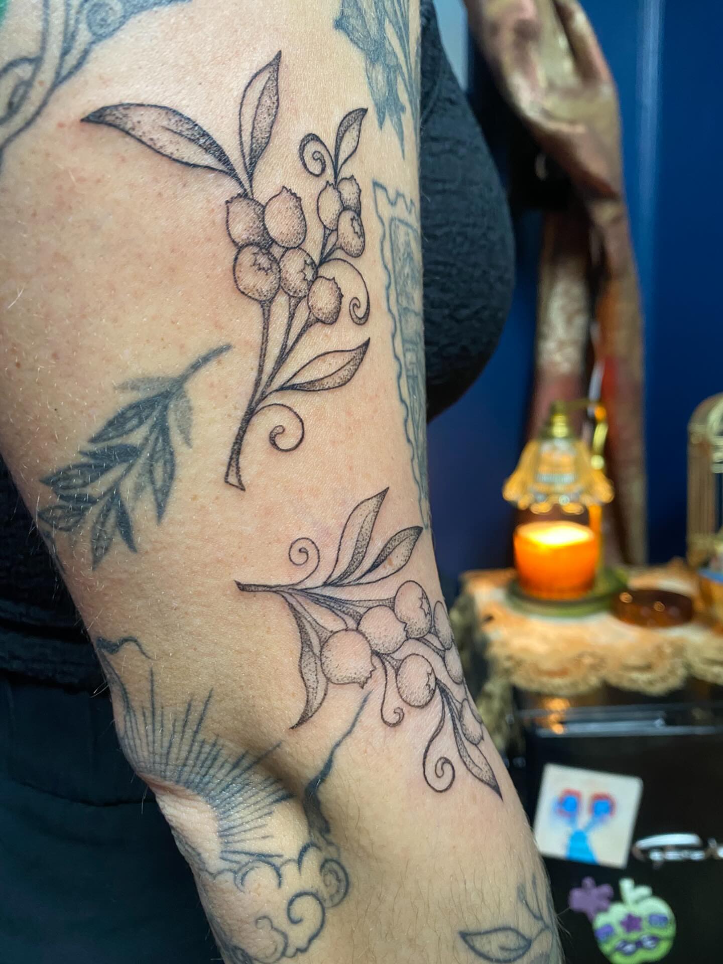 Berry branch black and grey tattoo on the upper arm by Jesikah Rapp