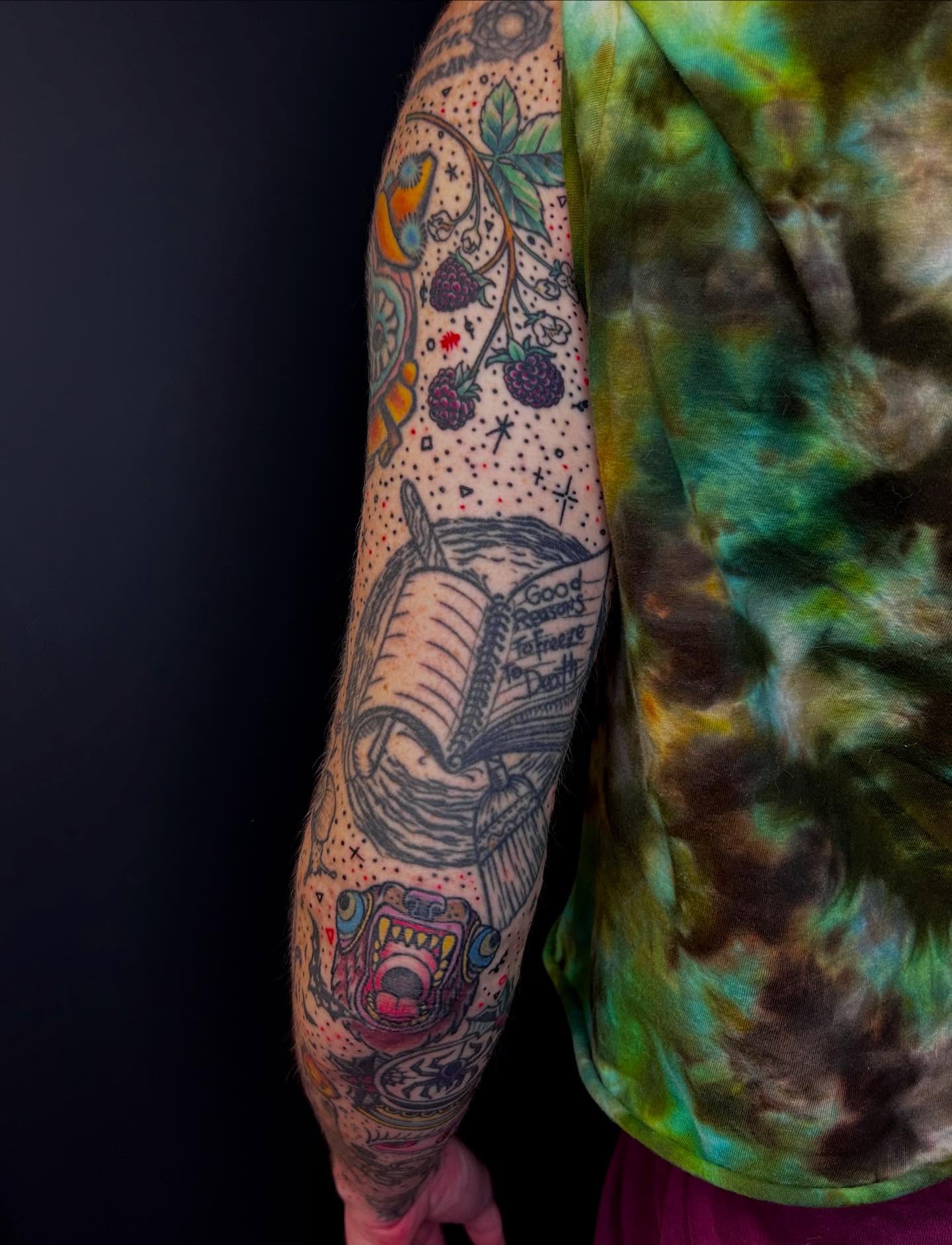 Book and fruit dotwork tattoo on the forearm by Jon Byrd