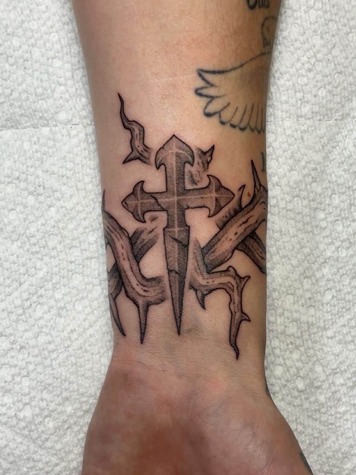 Cross with thorns black and grey tattoo on the forearm by Izabelle Inks