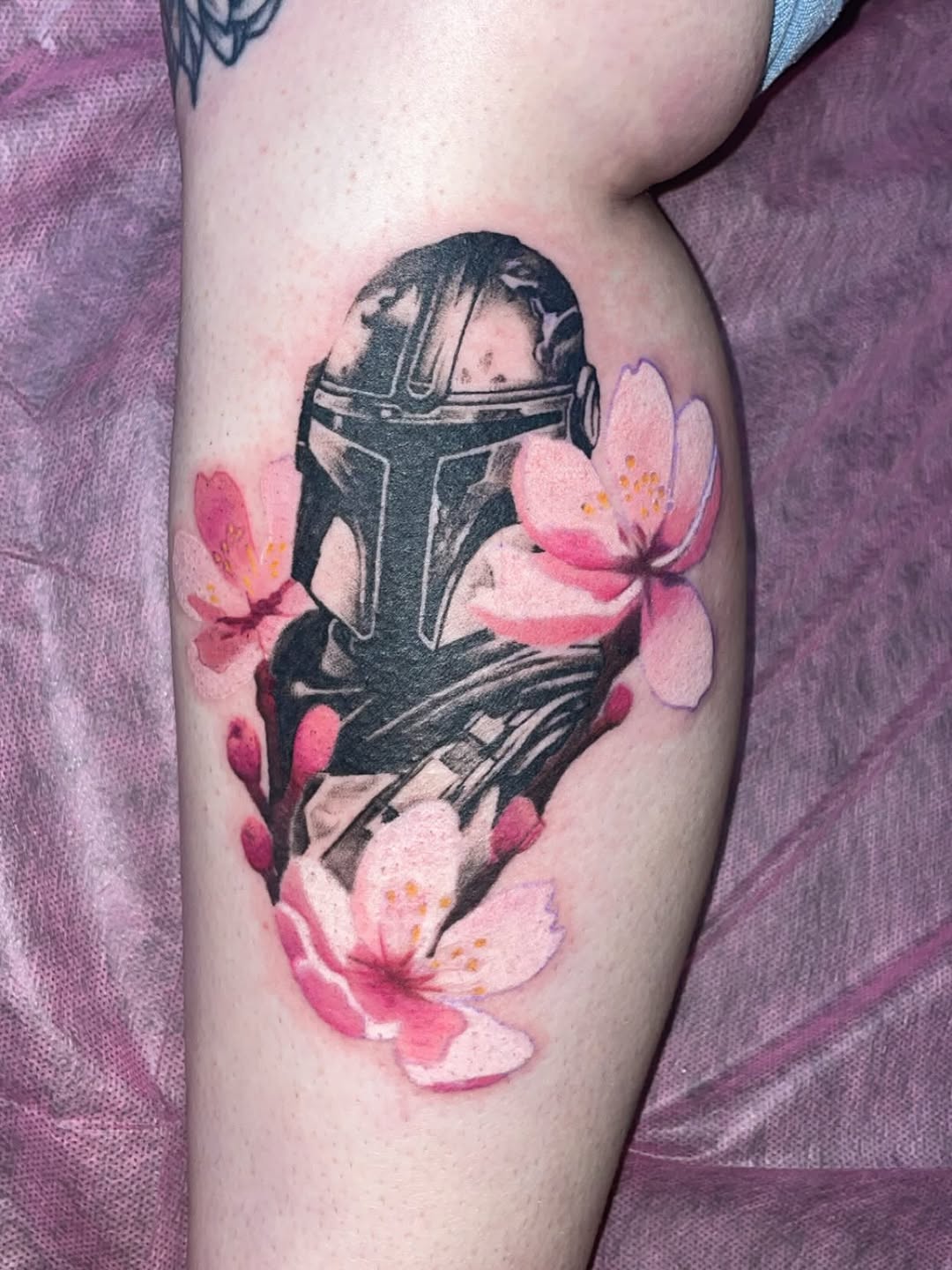 Mandalorian helmet with cherry blossoms new school tattoo on the thigh by Natalie