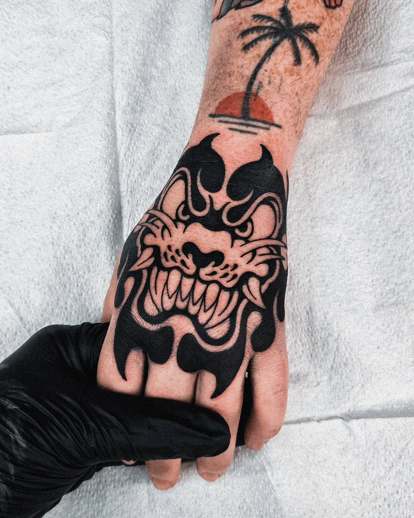Flaming skull black and grey tattoo on the hand by Jeremy "Jerms" Camposanto