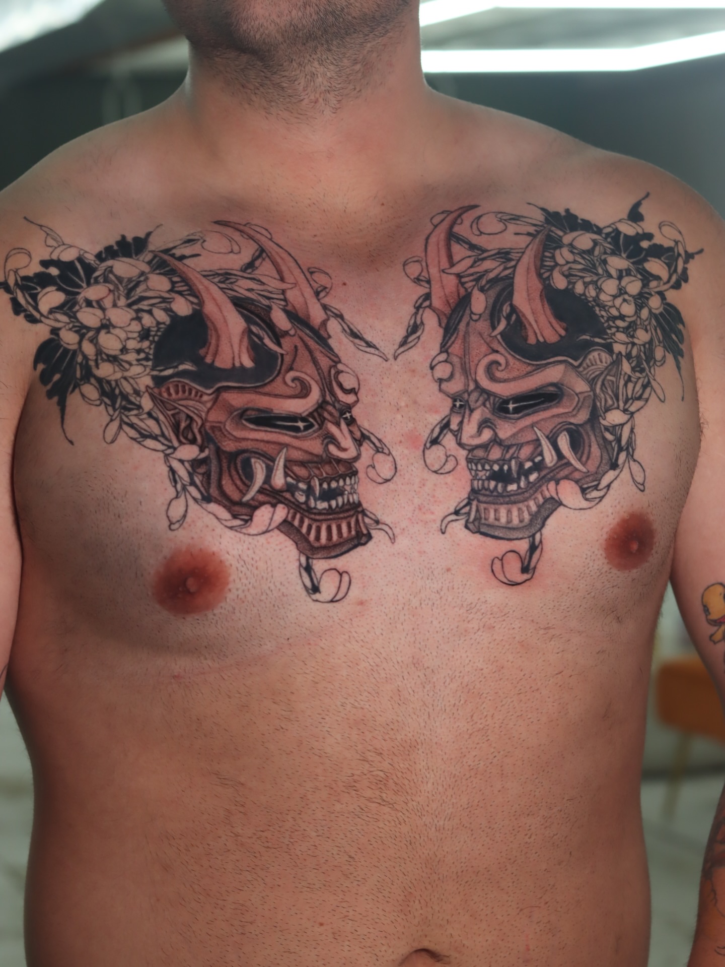 Mask and flowers japanese irezumi tattoo on the chest by Melissa C, Phoenix, Arizona