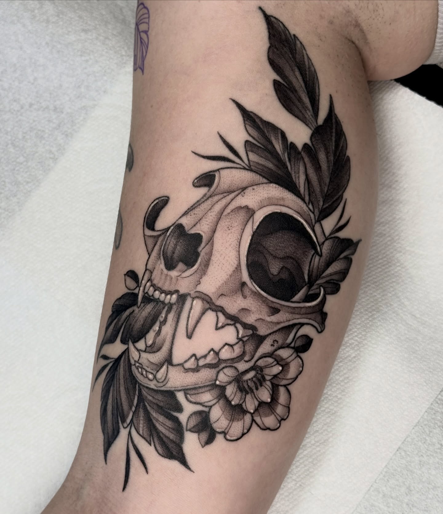 Skull and floral realism tattoo on the forearm by Hannah May, La Mesa, California