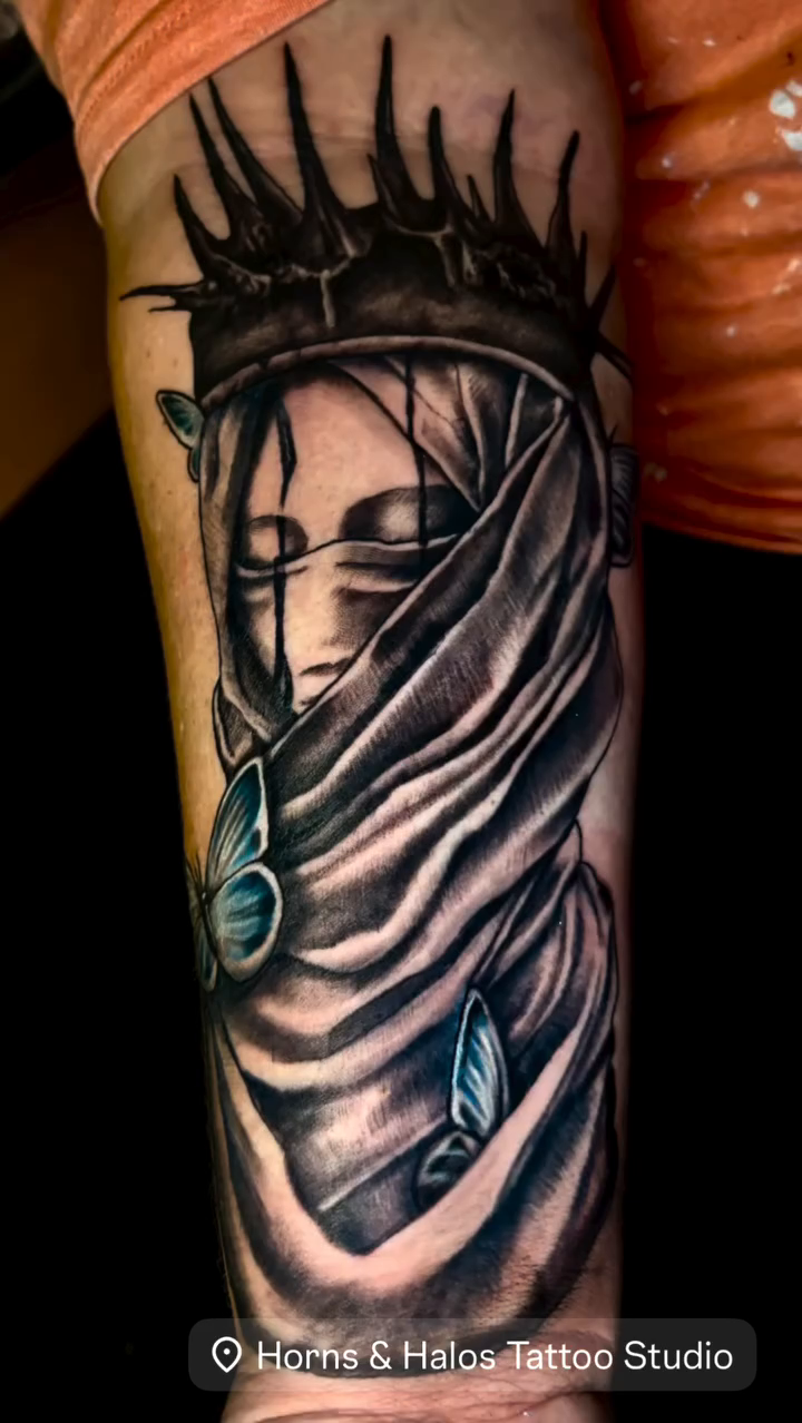 A veiled woman with a crown realism tattoo on the forearm by Deacon Moser