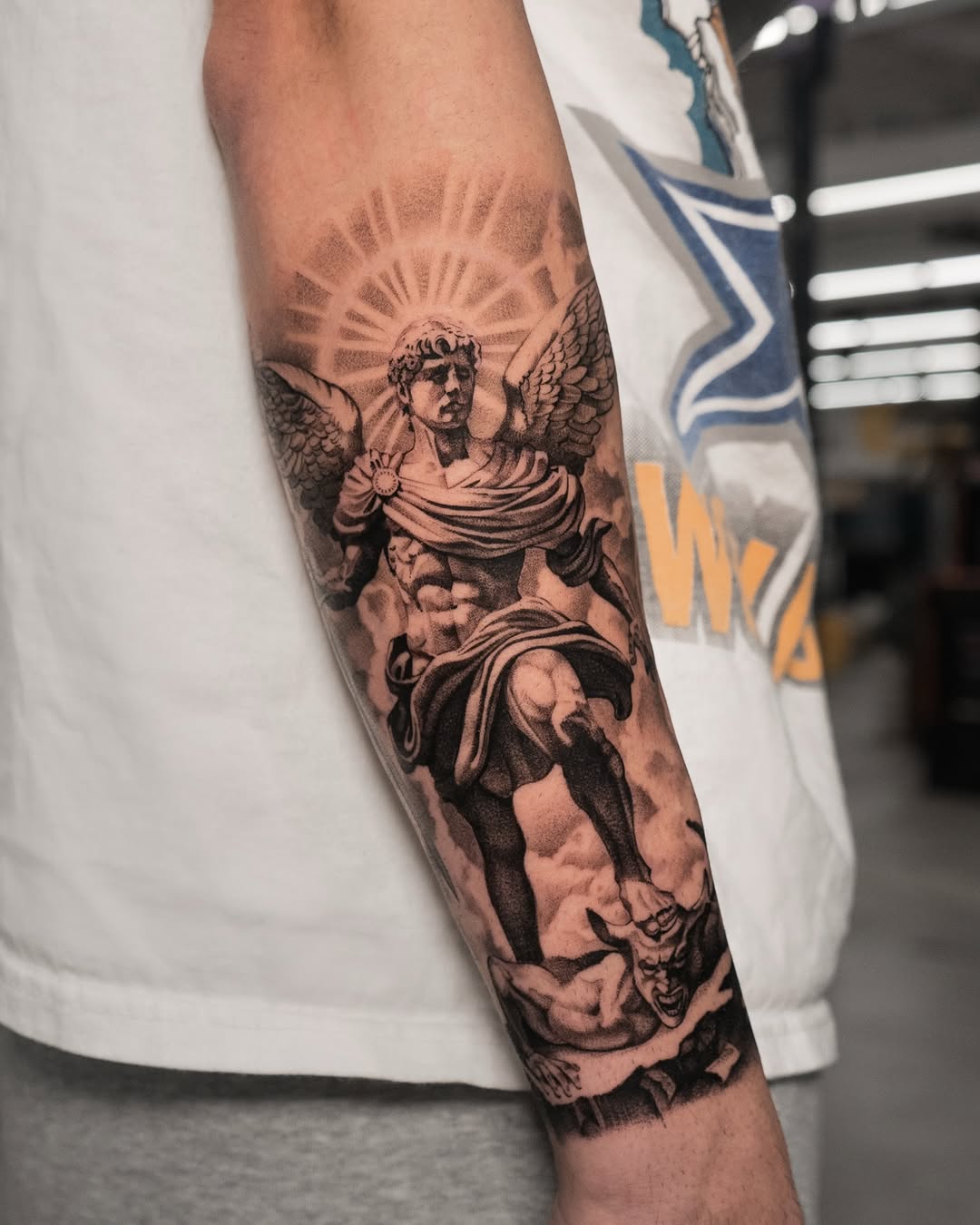 Archangel Michael defeating a demon realism tattoo on the forearm by Mateo