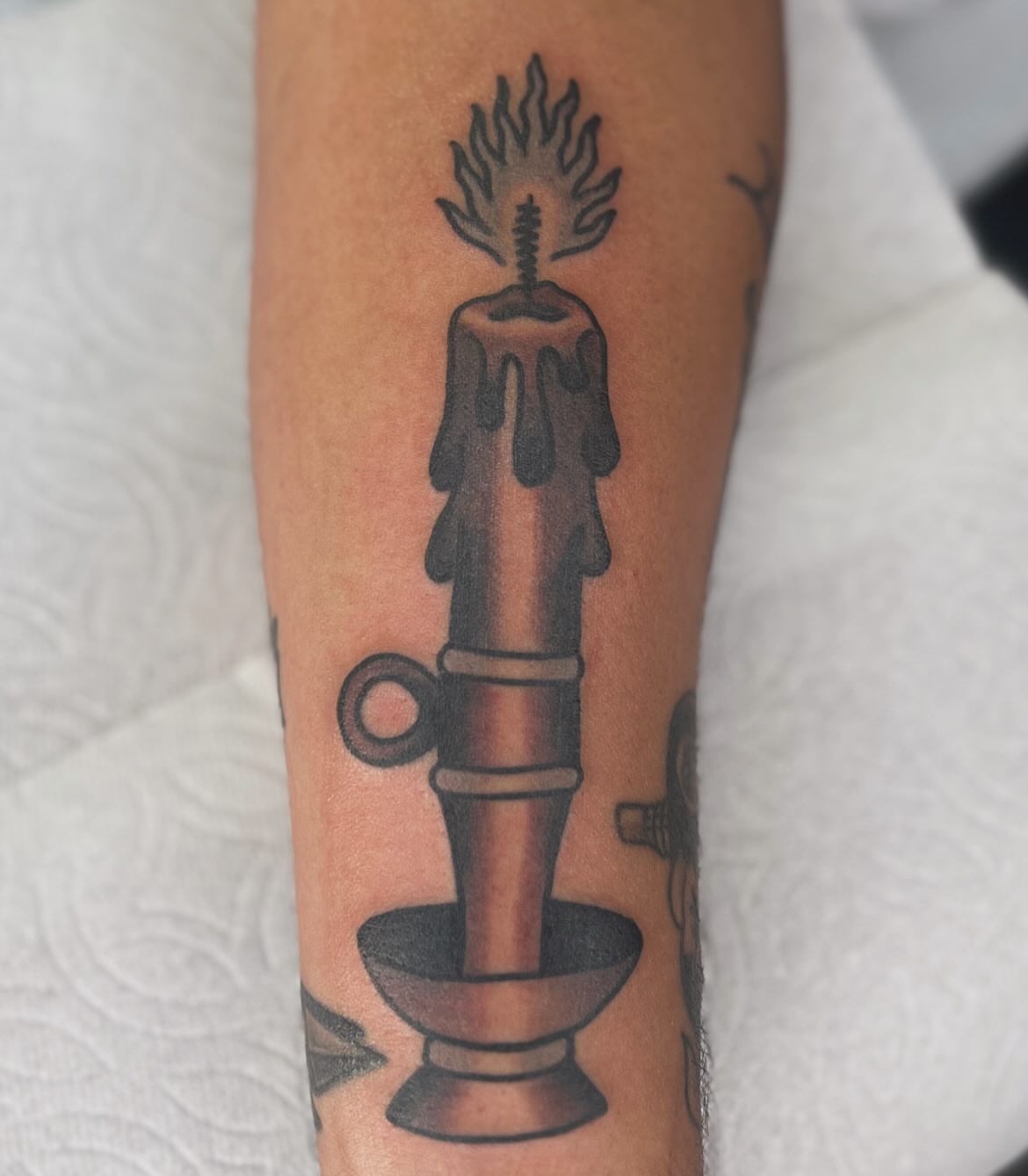Candle black and grey tattoo on the forearm by Mikey Montoya
