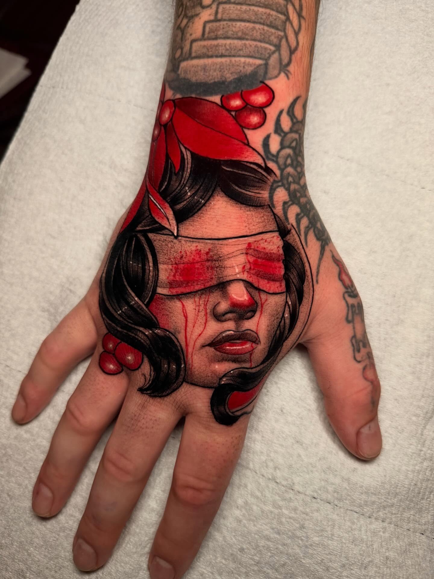 Woman with blindfold realism tattoo on the hand by Robert Graye