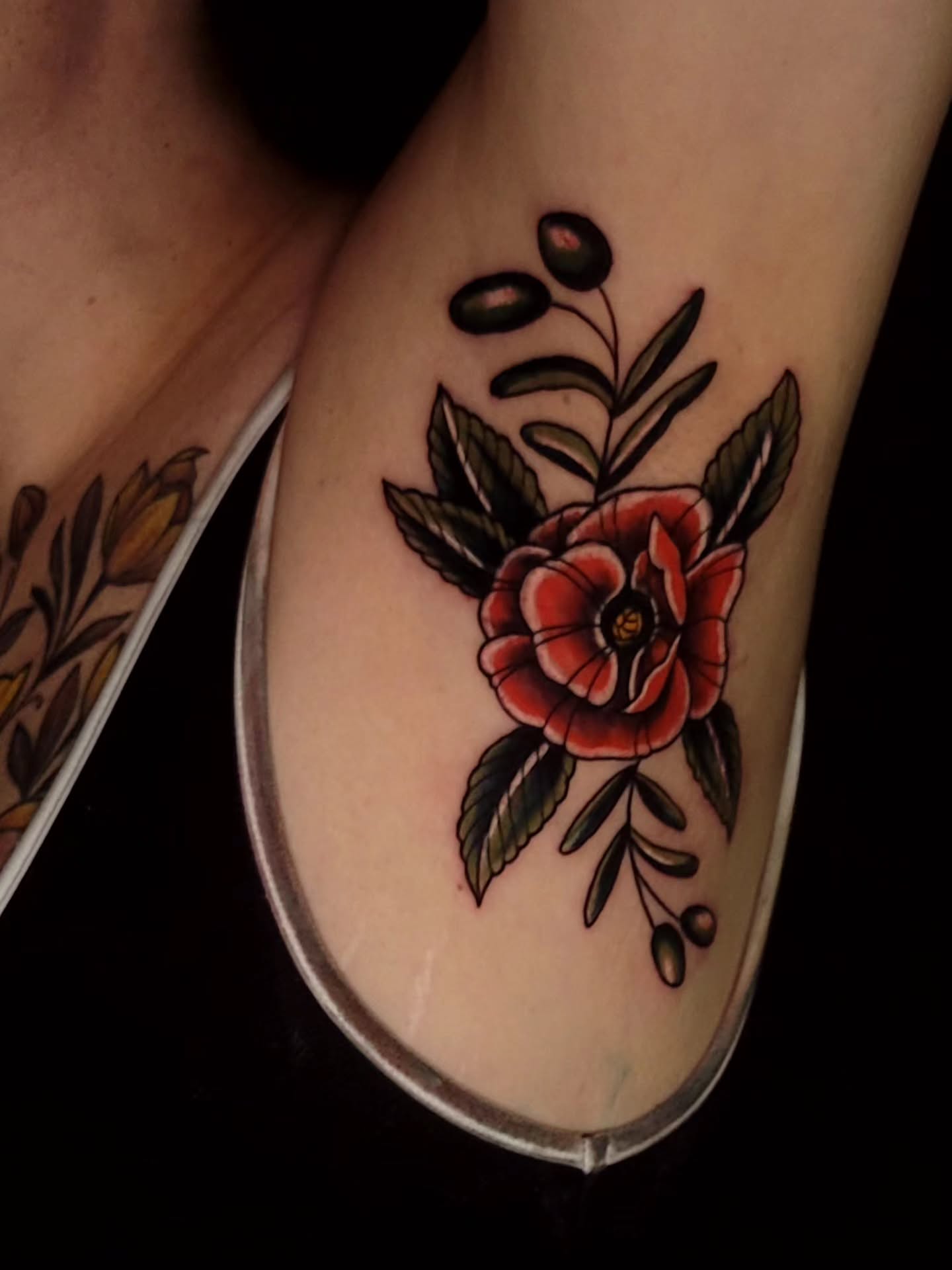 Red poppy American traditional tattoo on the forearm by Tyler Monty