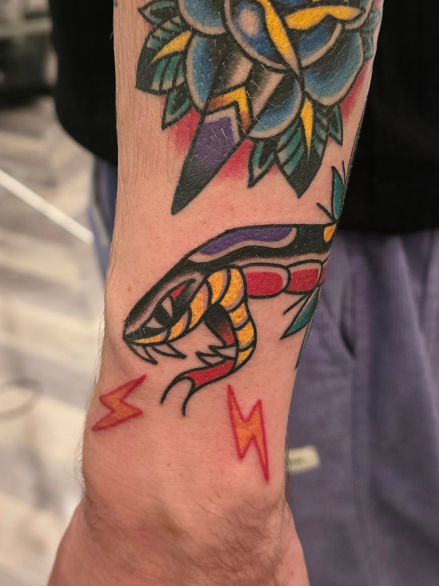 Snake and lightning bolts American traditional tattoo on the forearm by A. Teixeira, Los Angeles, California