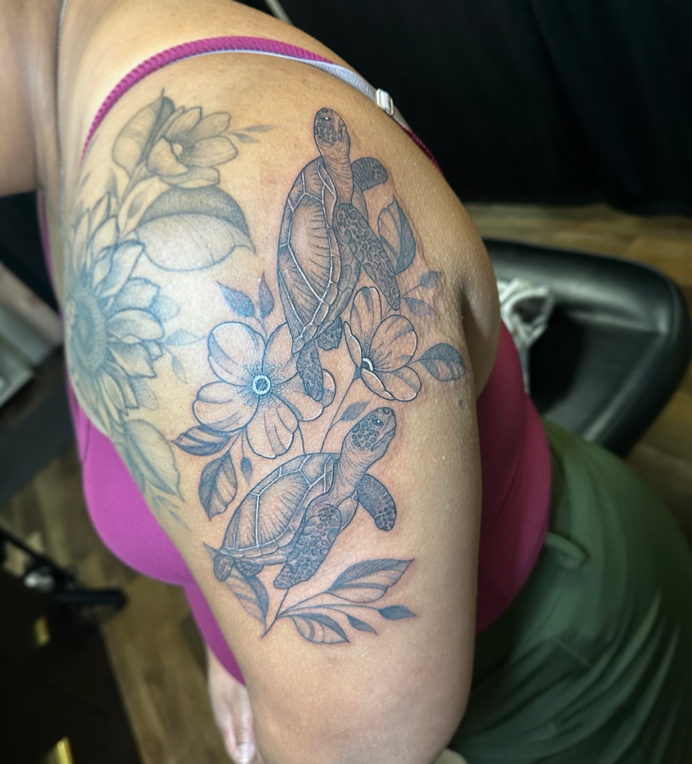 Sea turtles and flowers black and grey tattoo on the shoulder by Priscilla Michels