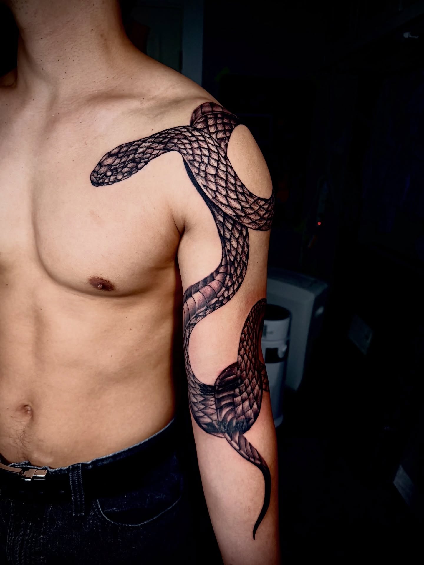Snake black and grey tattoo on the upper arm by John Ayson, Murrieta, California