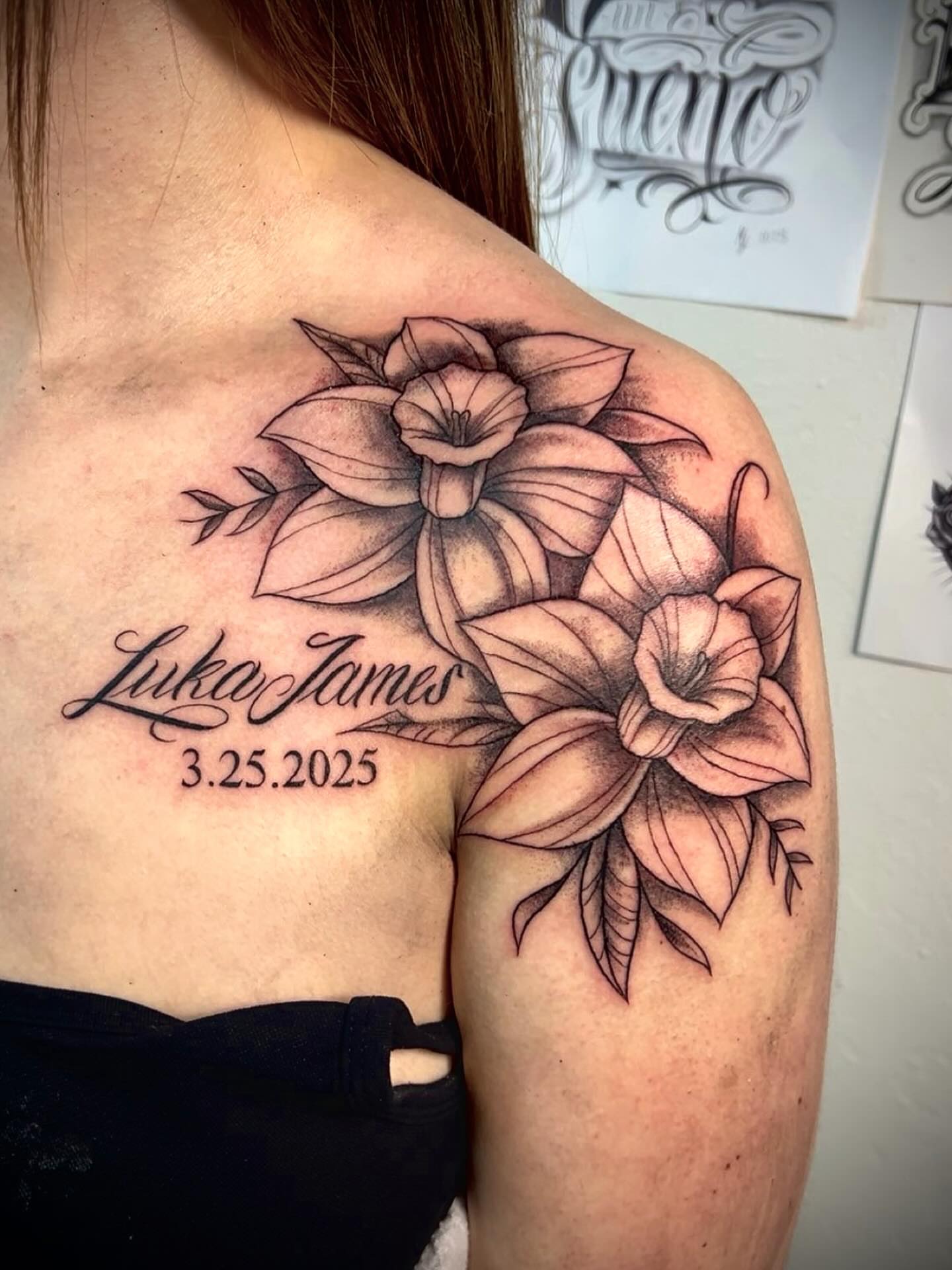 Flowers and name black and grey tattoo on the shoulder by Ximena Favela