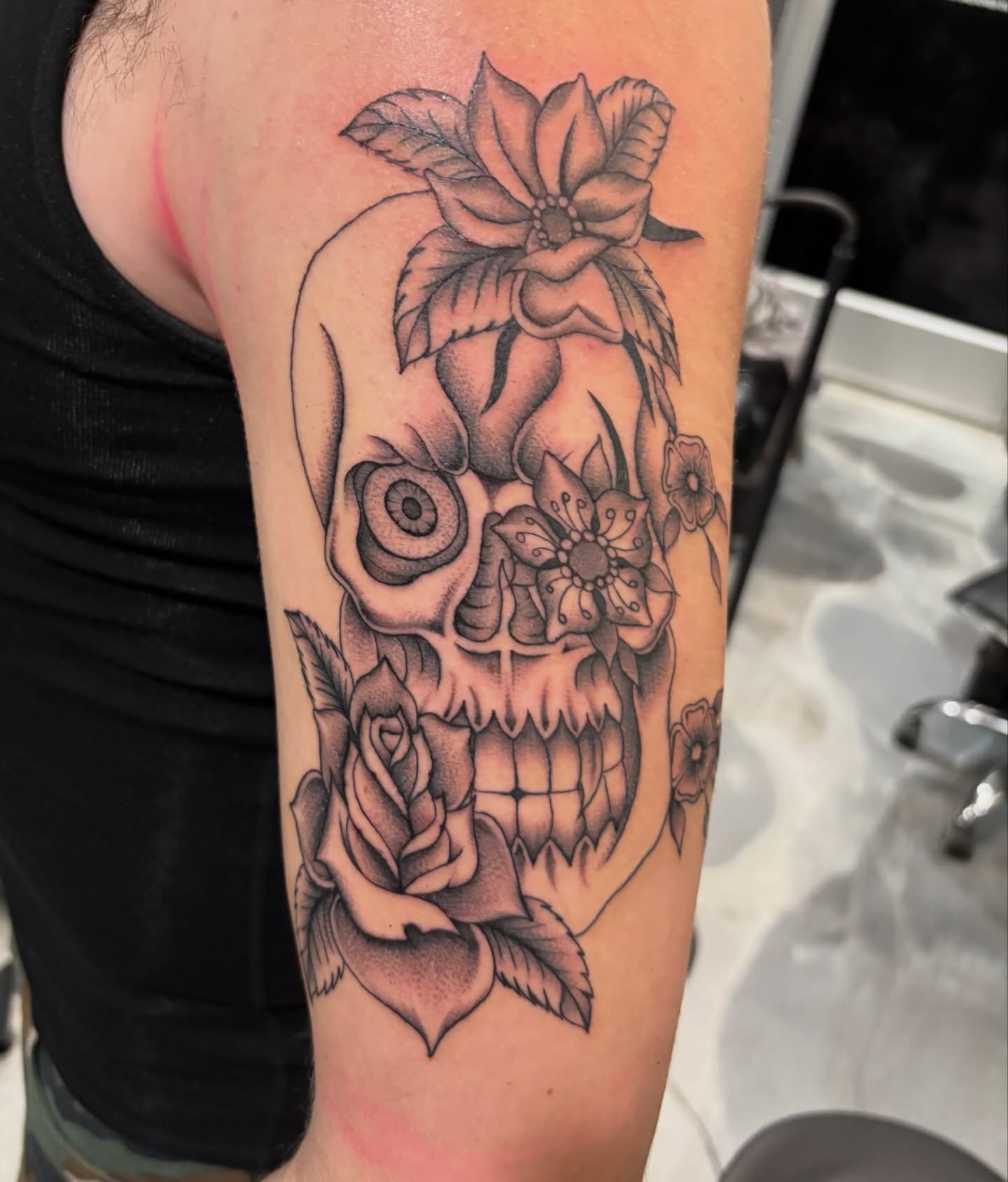 Skull with flowers realism tattoo on the forearm by Miklo Montoya