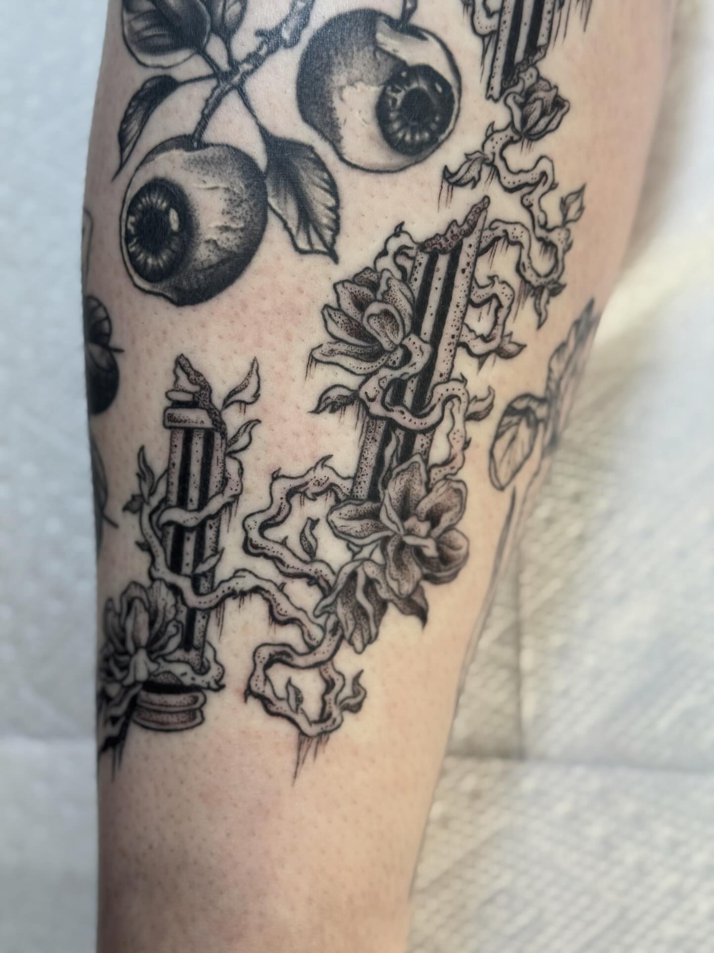 Eye and flowers black and grey tattoo on the forearm by Writhe Grey