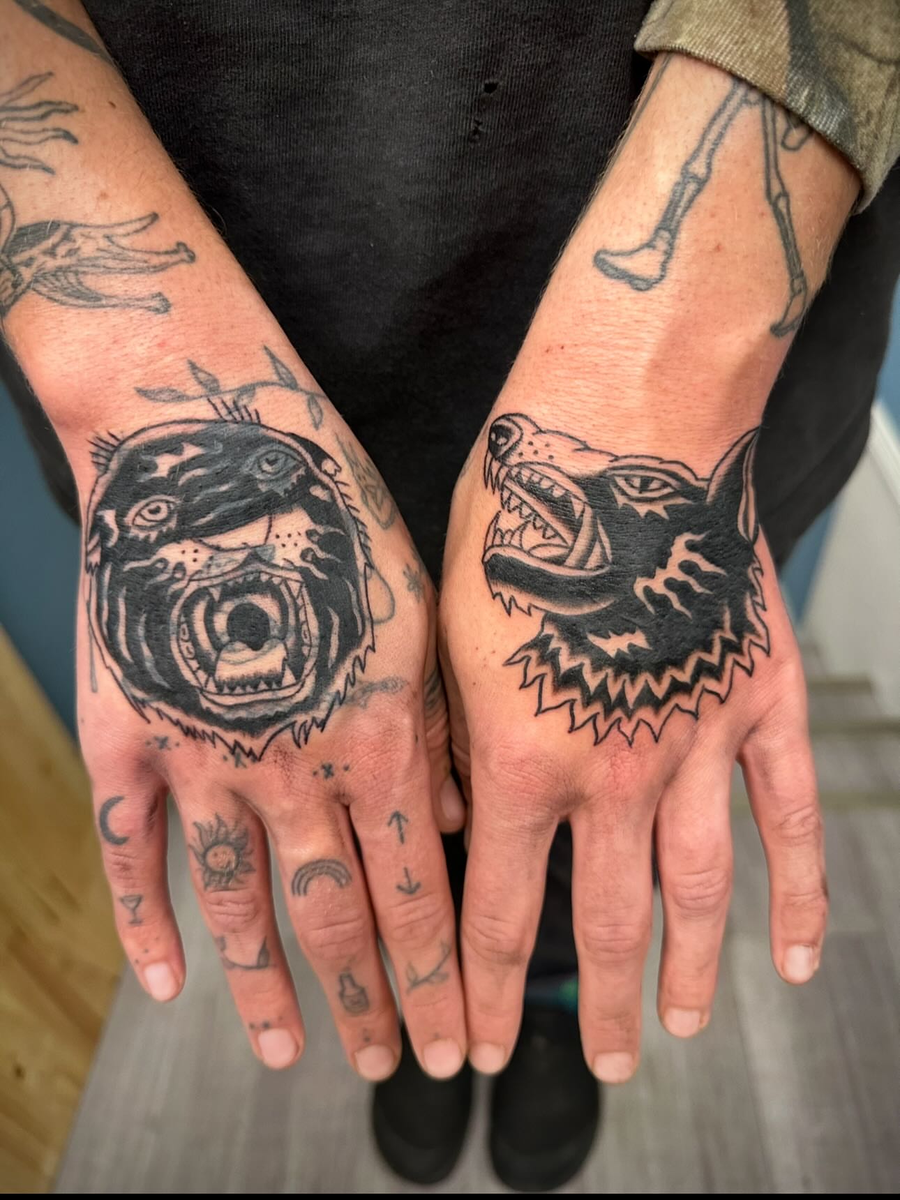 Wolf and bear black and grey tattoo on the hand by rory