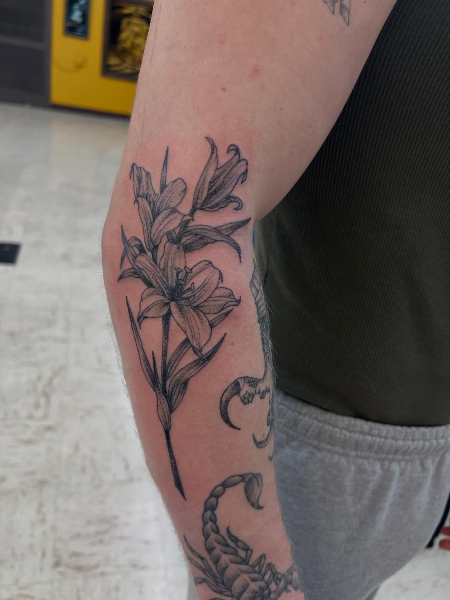 Lily black and grey tattoo on the forearm by Levi Sawdon, Everett, Washington