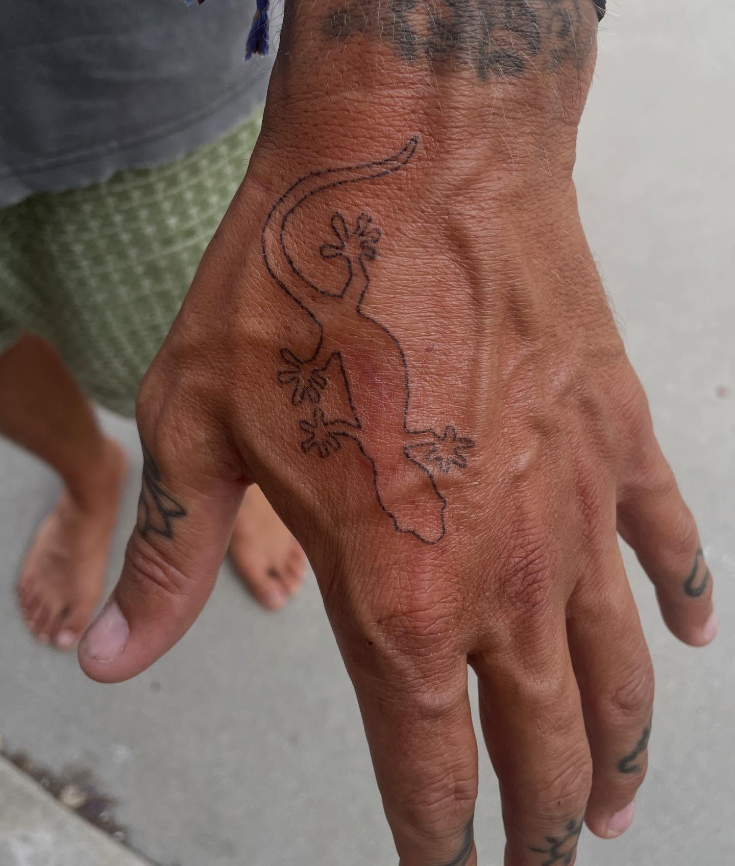 Gecko black and grey tattoo on the hand by Alyssa