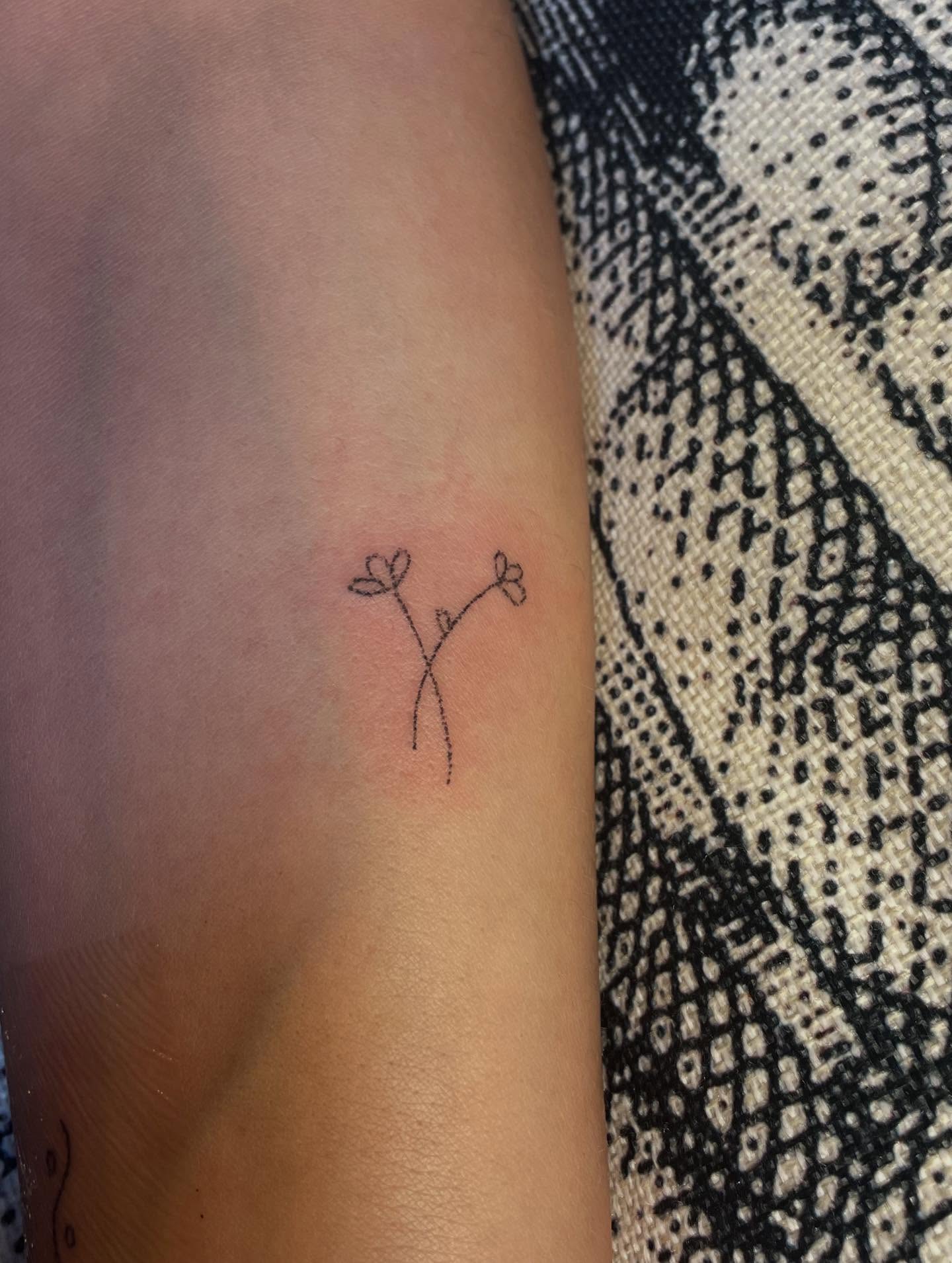 Flower fine line tattoo on the forearm by Alyssa