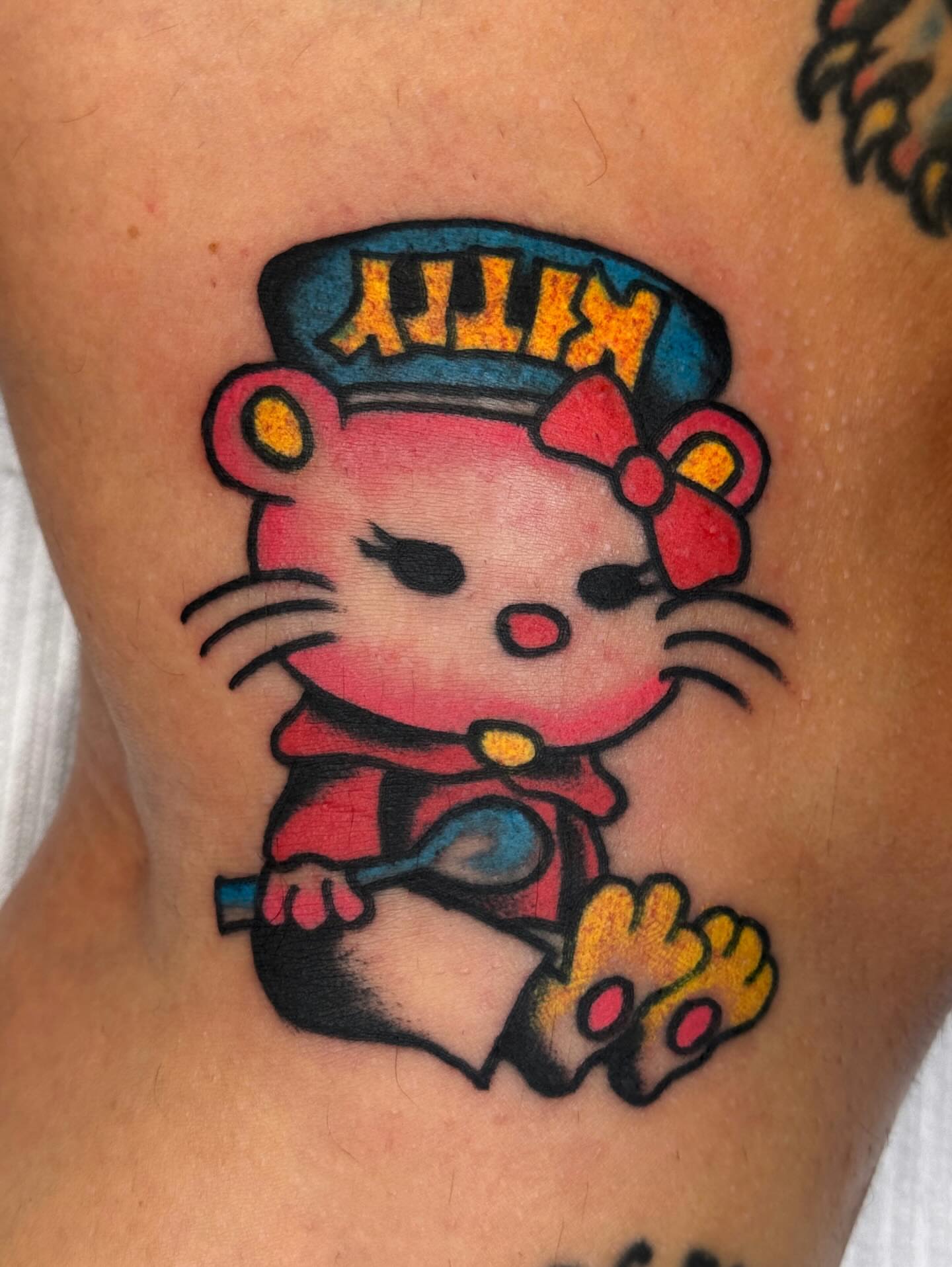 Hello Kitty new school tattoo on the thigh by Jimmy Ho