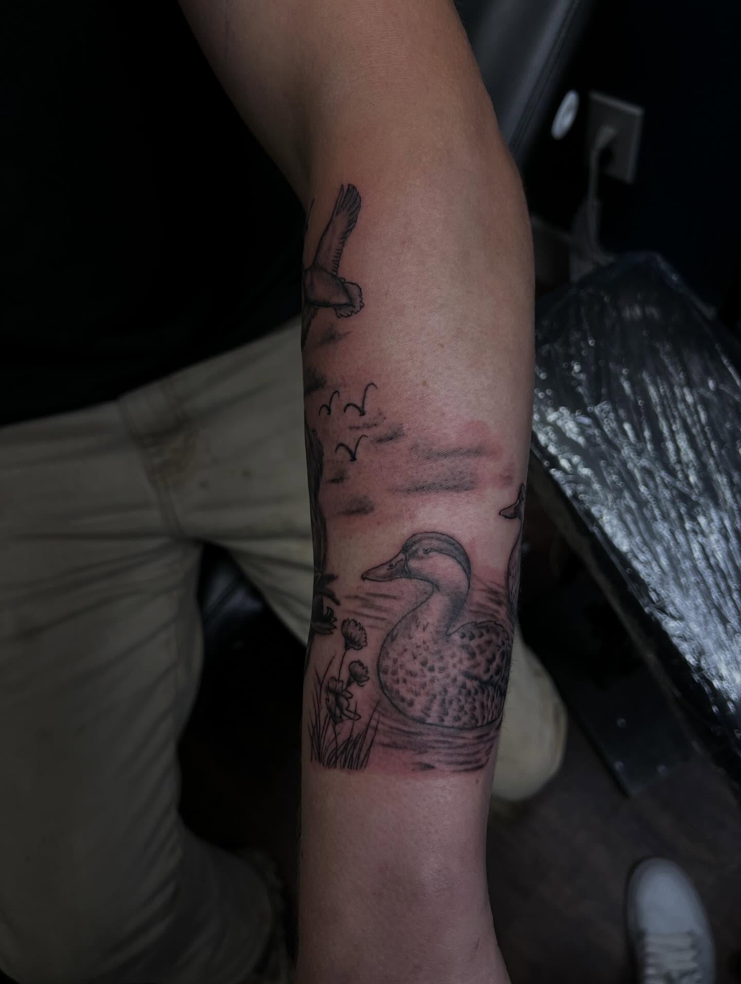 Duck and pond black and grey tattoo on the forearm by Glass Inkk