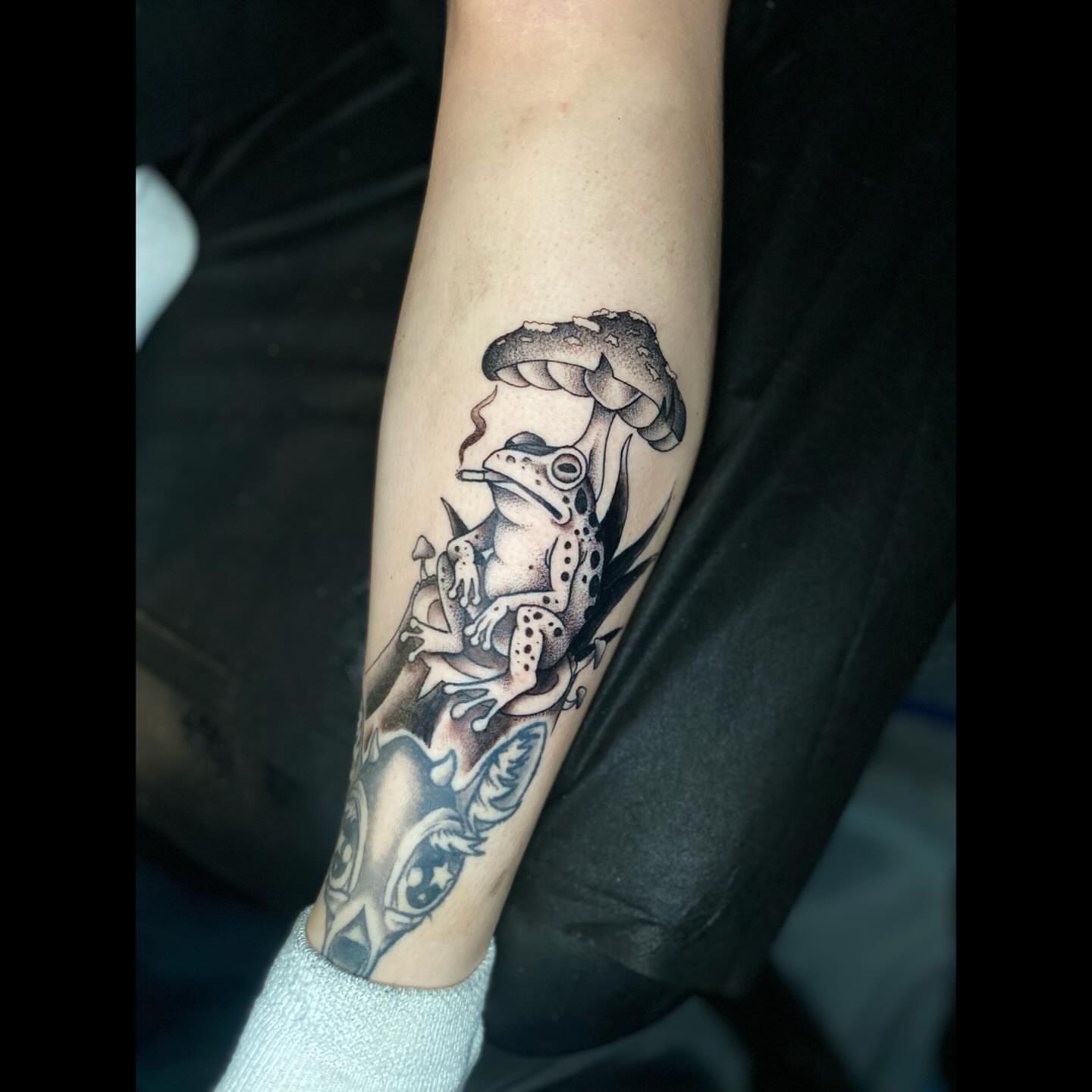Frog and mushrooms dotwork tattoo on the forearm by Shelby Warren
