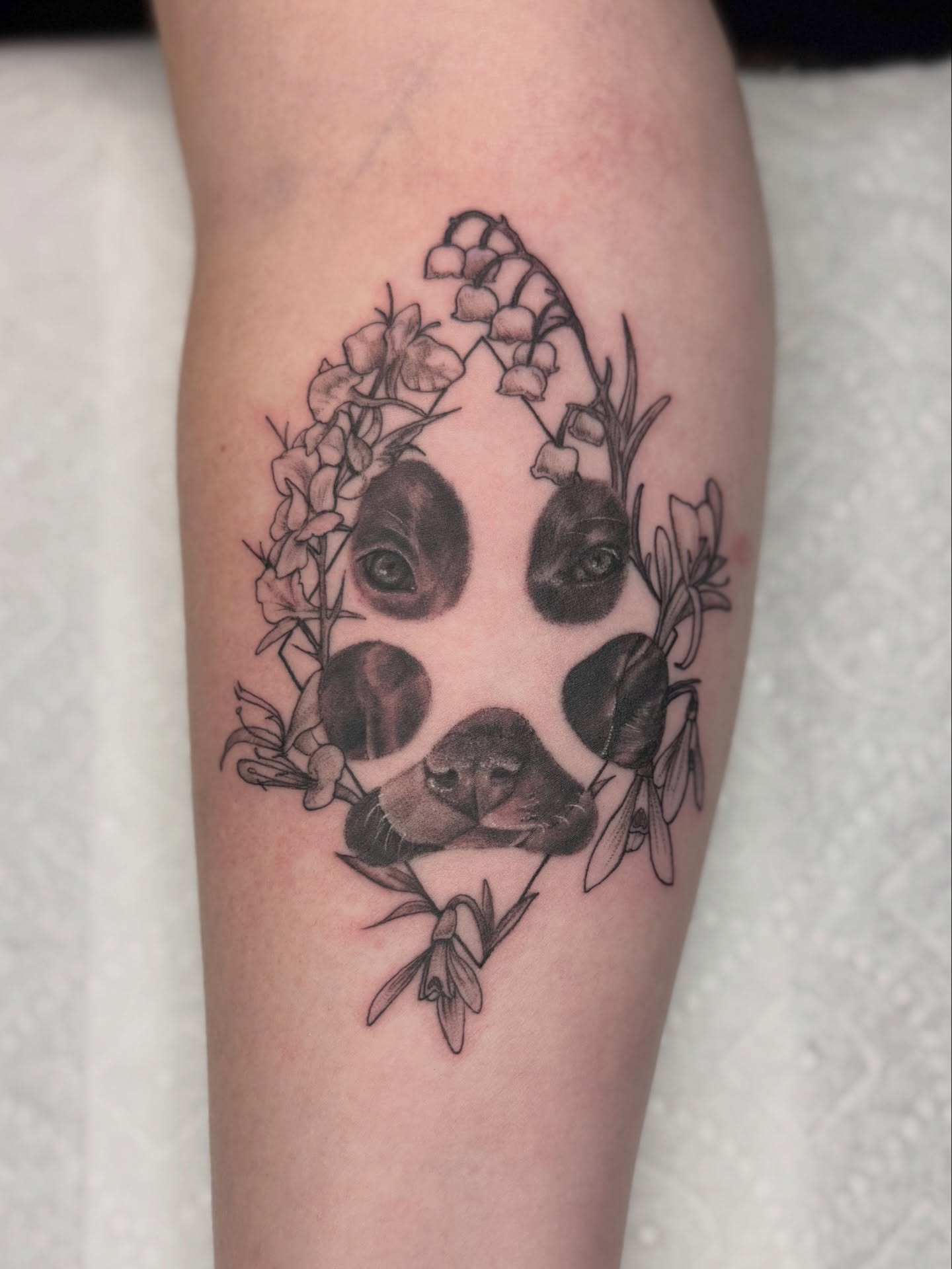 Panda with flowers realism tattoo on the forearm by Kelsey Kemp