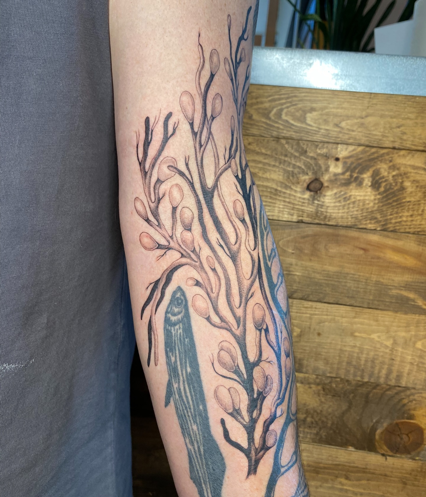 Tree and fish dotwork tattoo on the forearm by Avery Kane