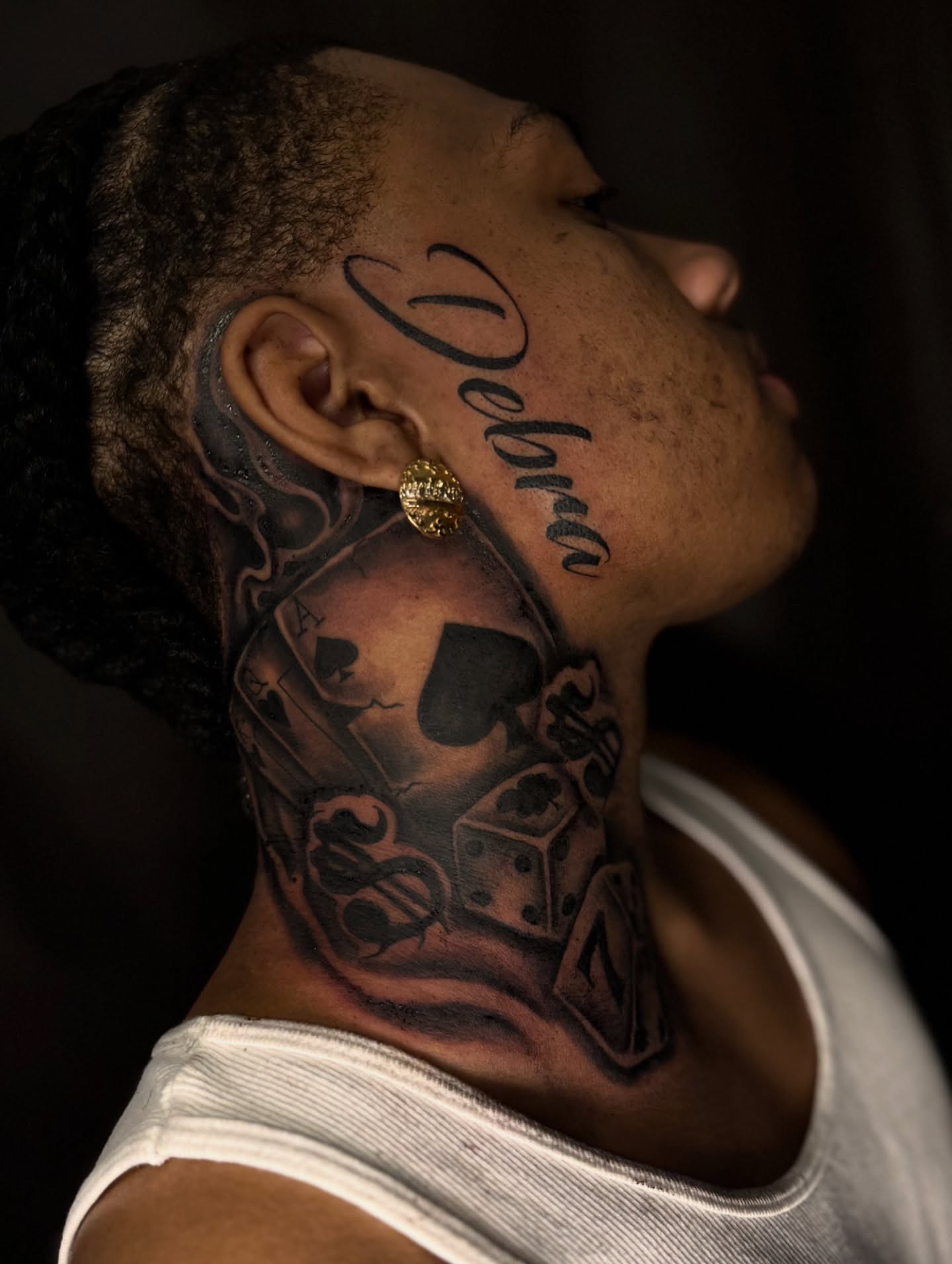 Playing card and dice black and grey tattoo on the neck by Elijah East