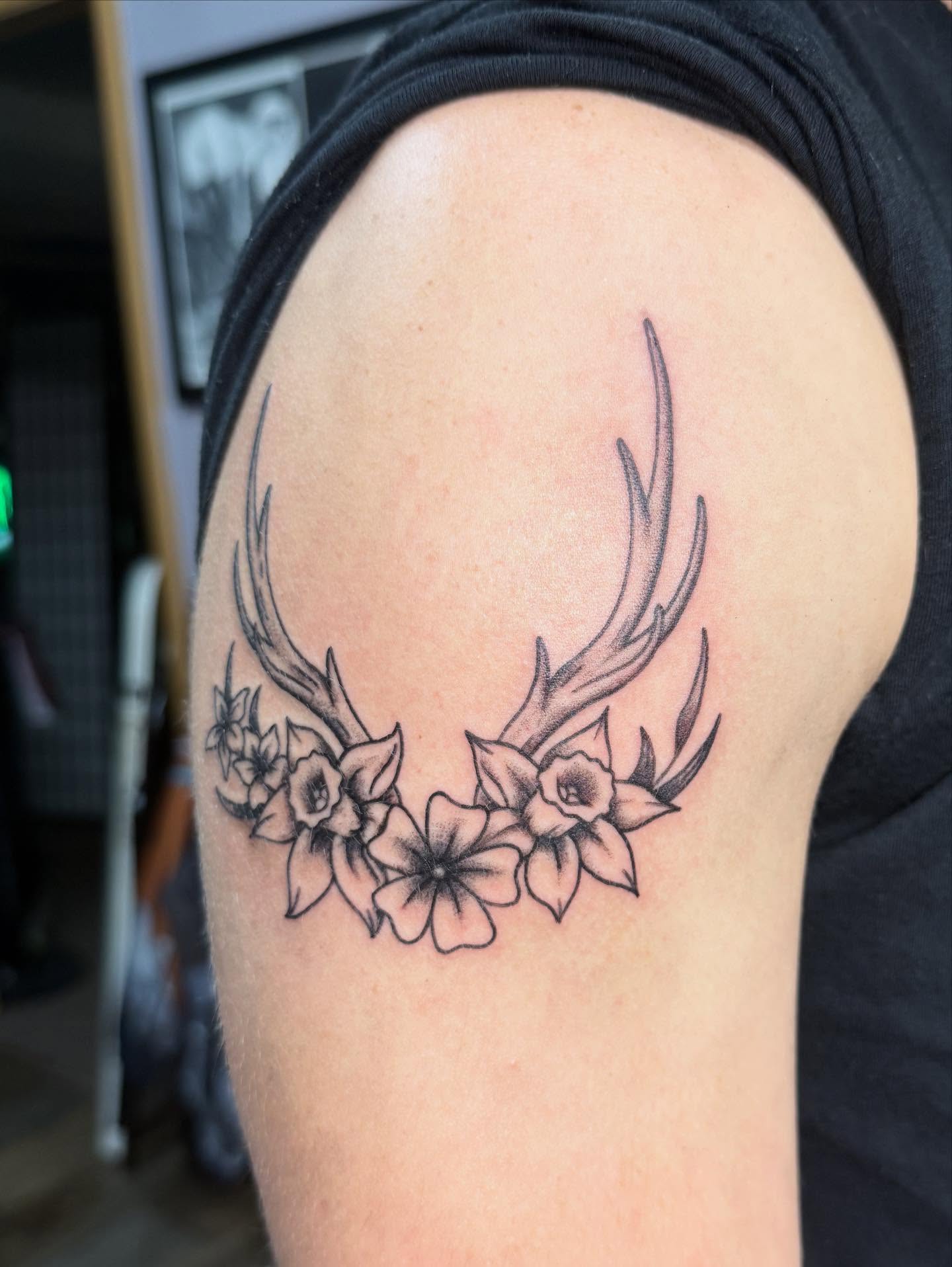 Antlers and flowers black and grey tattoo on the shoulder by Hunter Beyer