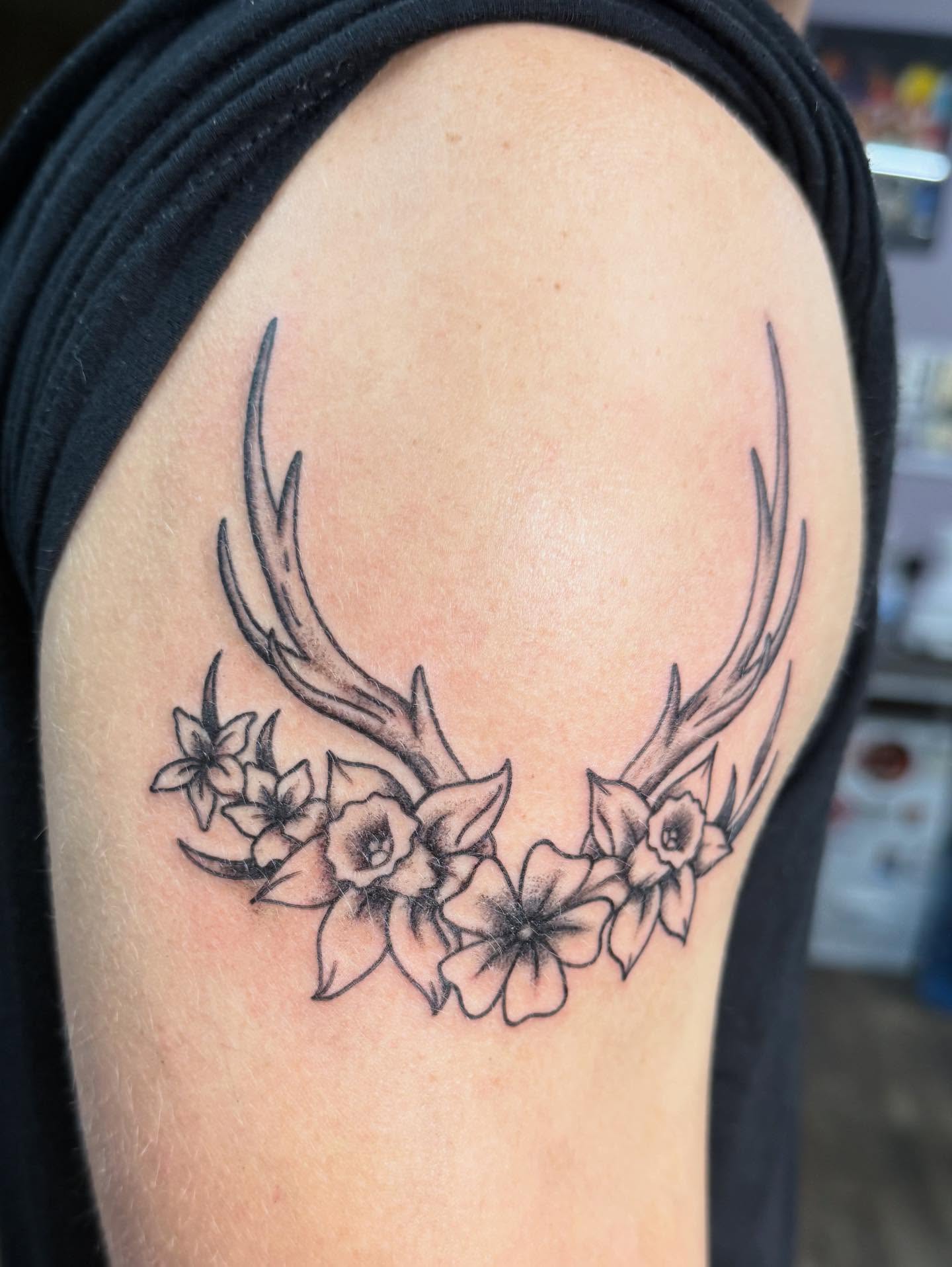 Antlers and flowers black and grey tattoo on the shoulder by Hunter Beyer