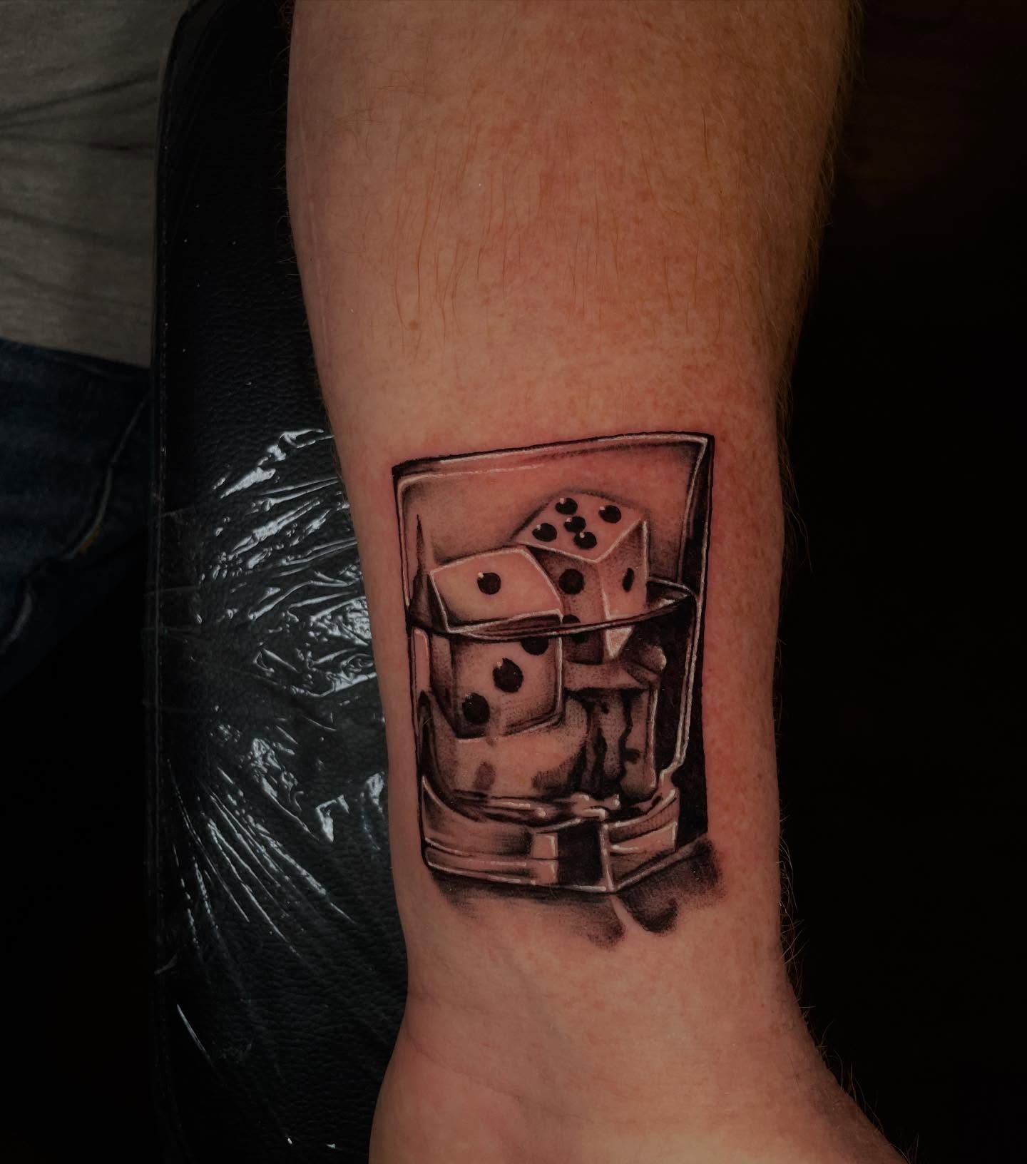 Dice in glass realism tattoo on the forearm by Lauren Sisouphanh, Canton, Ohio