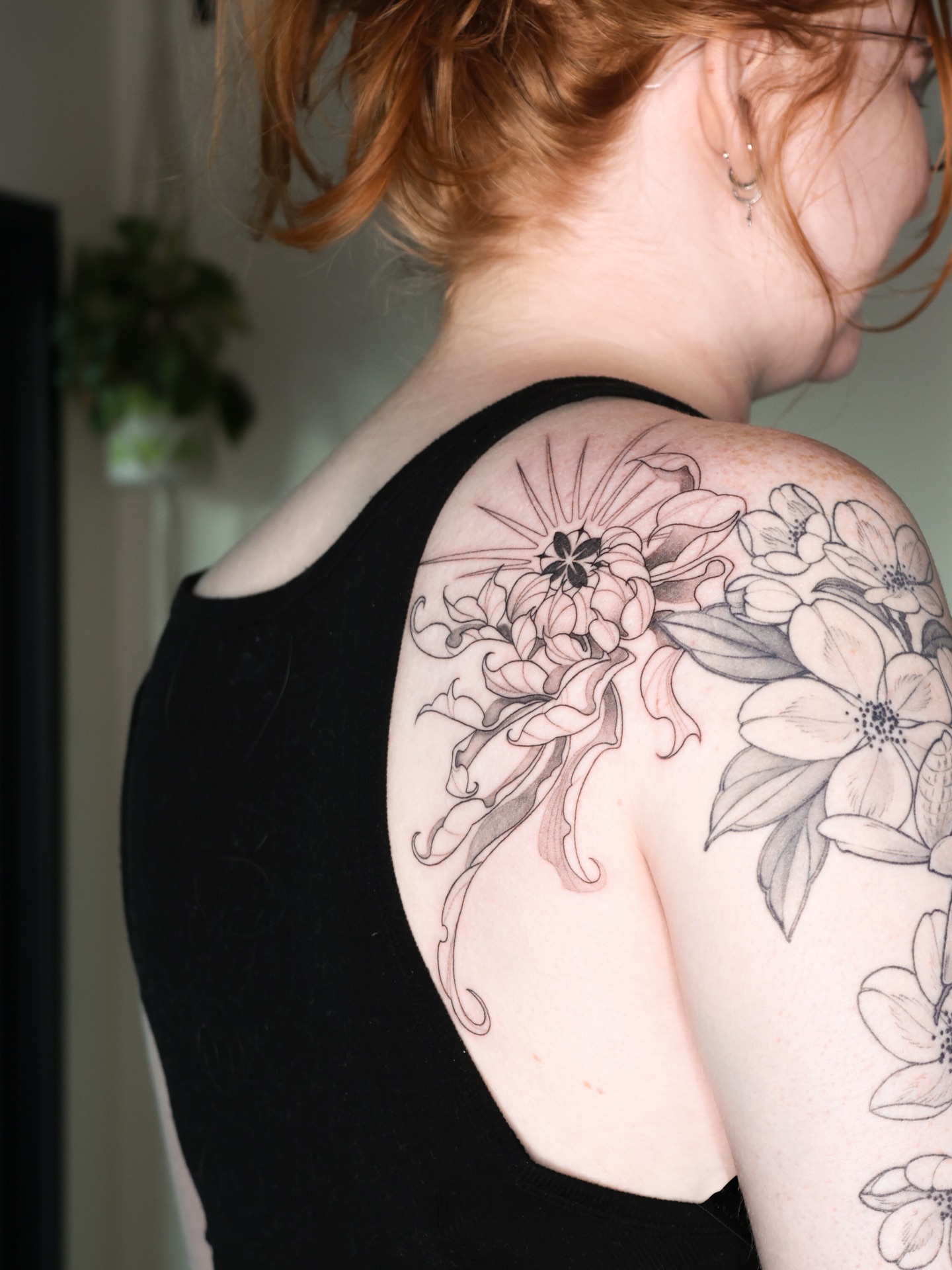 Floral arrangement black and grey tattoo on the shoulder by Beans