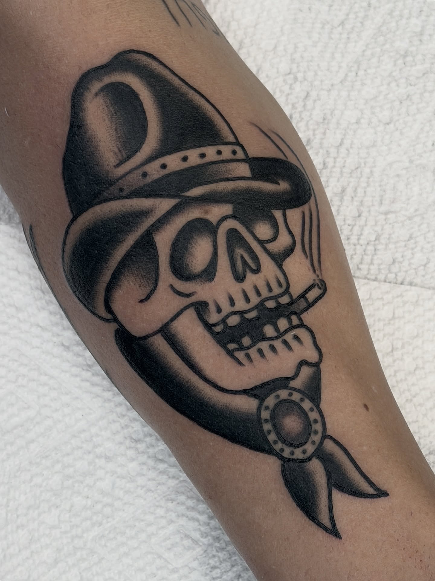 Skull wearing hat black and grey tattoo on the forearm by Cory Craft