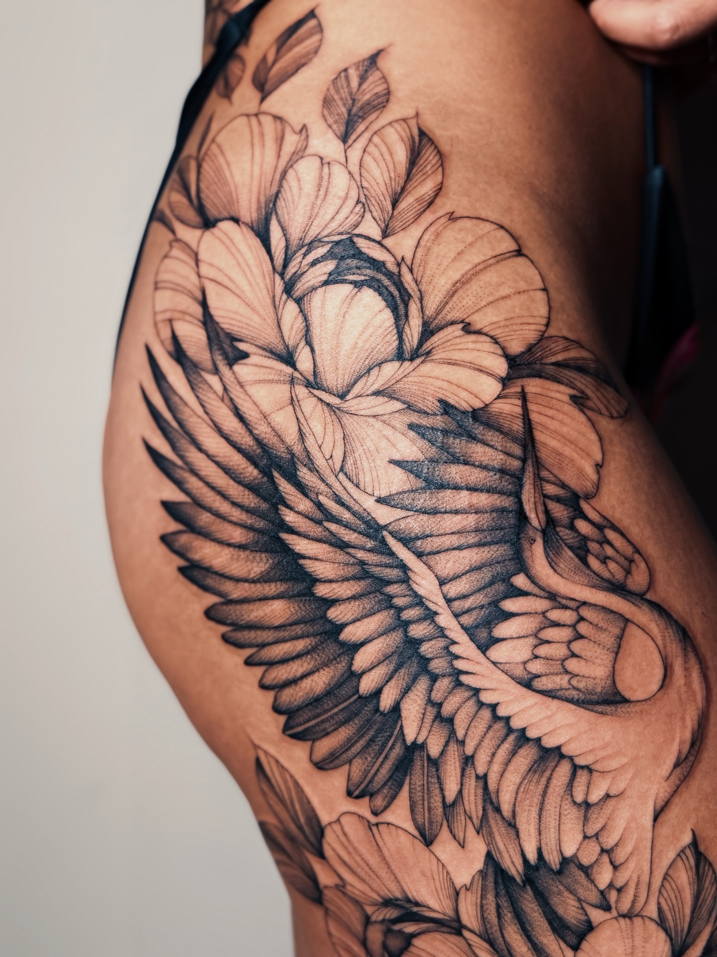 Winged flower realism tattoo on the thigh by Olha Tytarenko