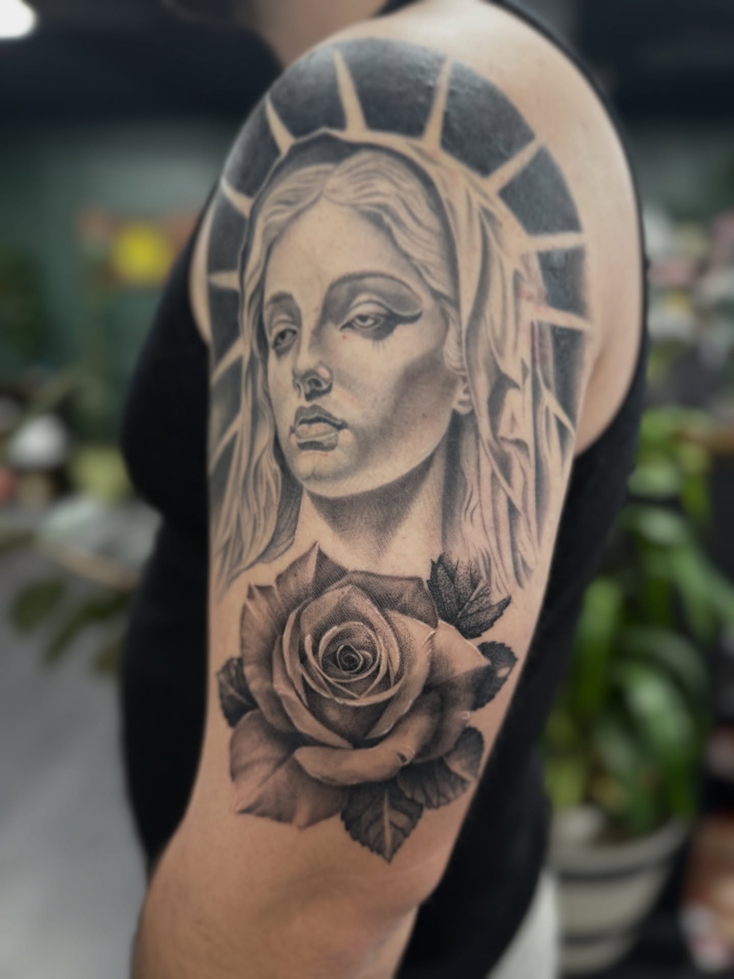 Woman with rose realism tattoo on the upper arm by Amber