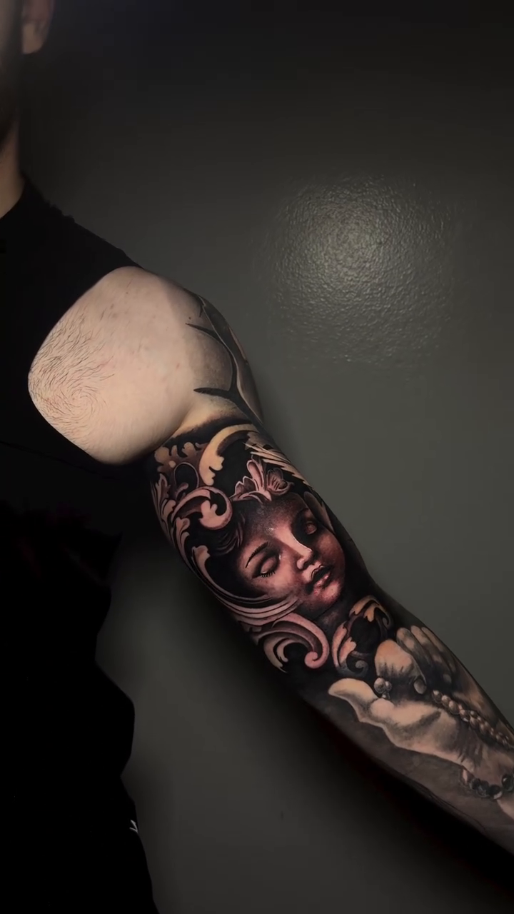 Cherub face with ornate filigree realism tattoo by caleb coley
