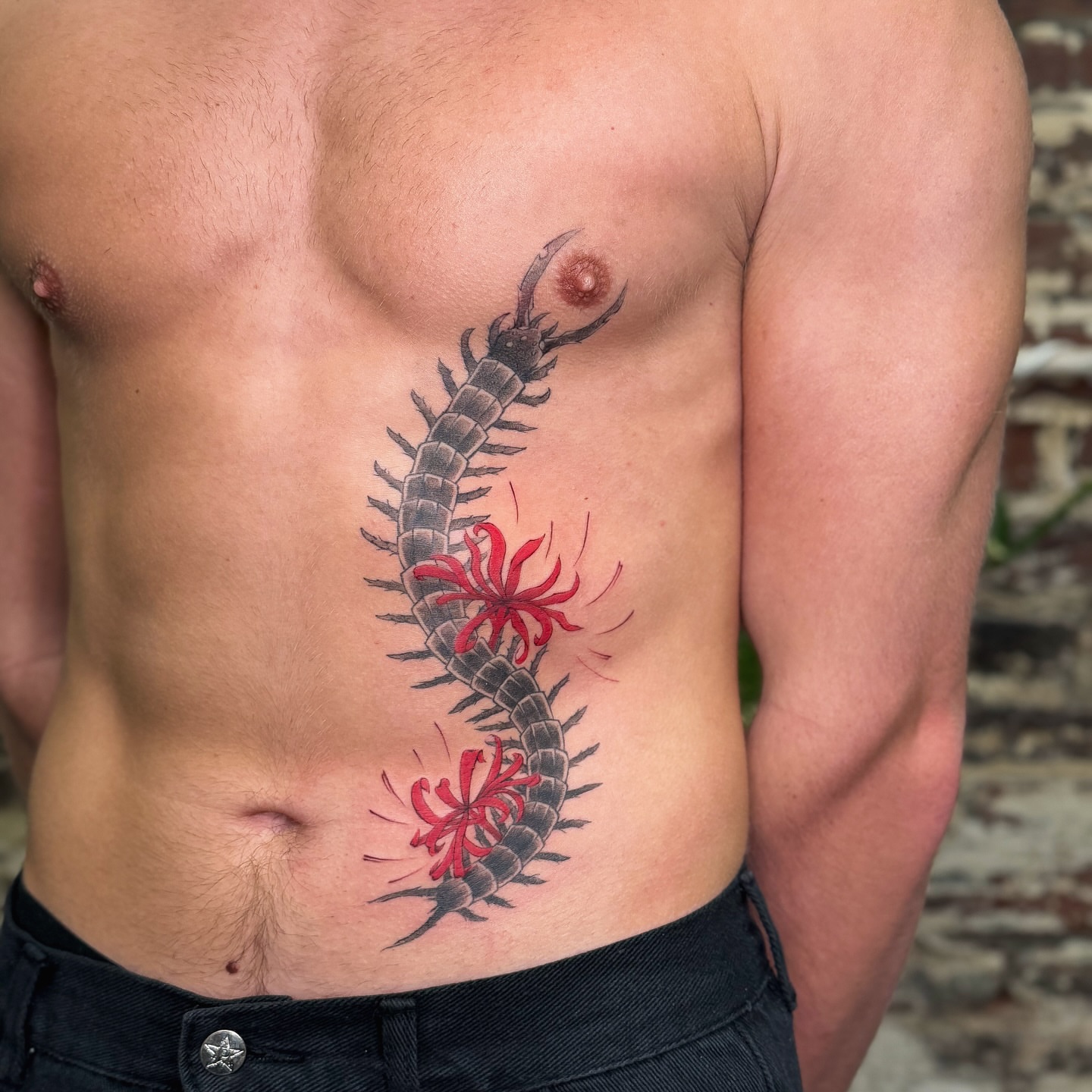Centipede and flowers realism tattoo on the torso by justin