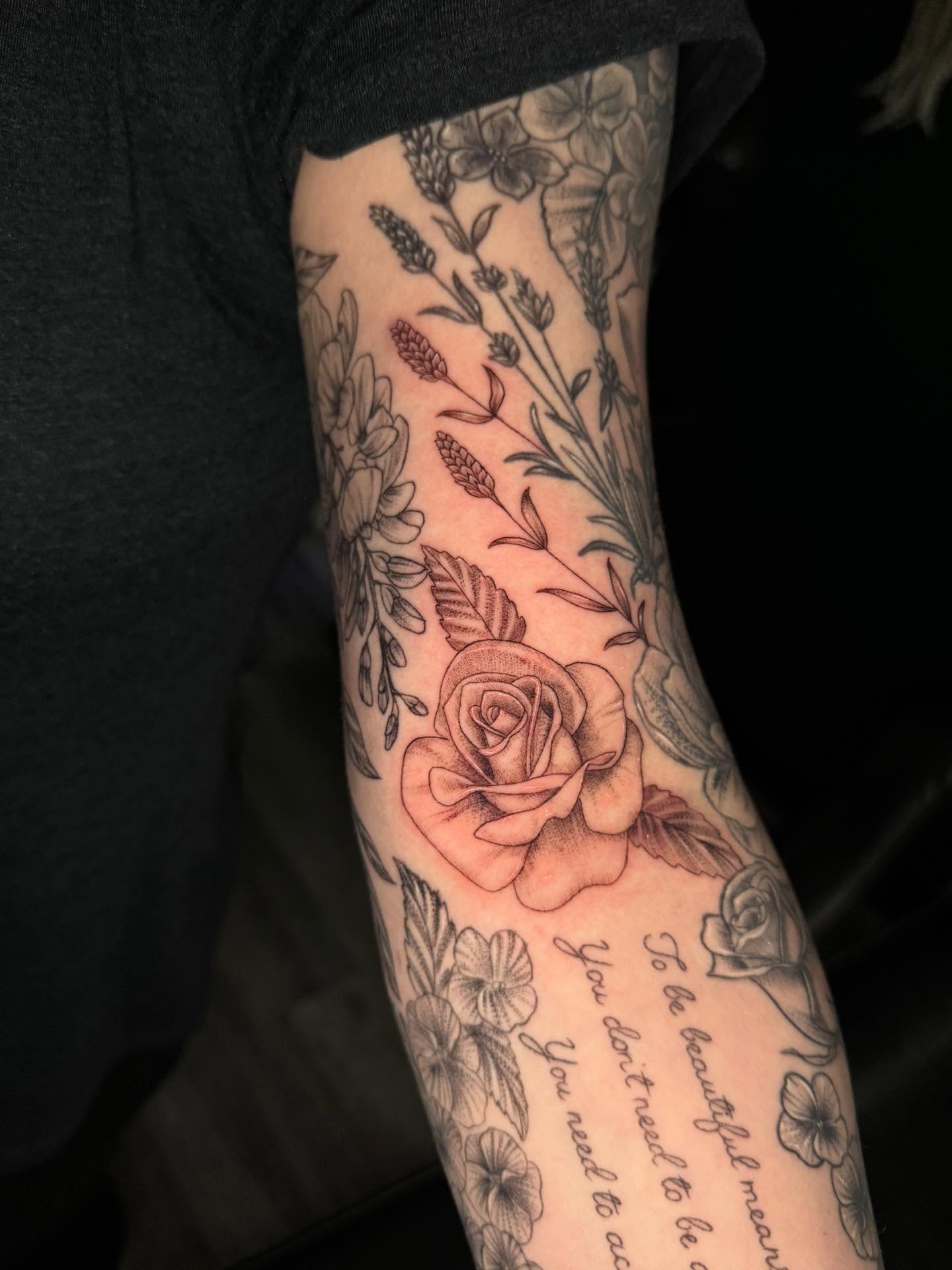 Rose and floral black and grey tattoo on the forearm by Leslea Hipp