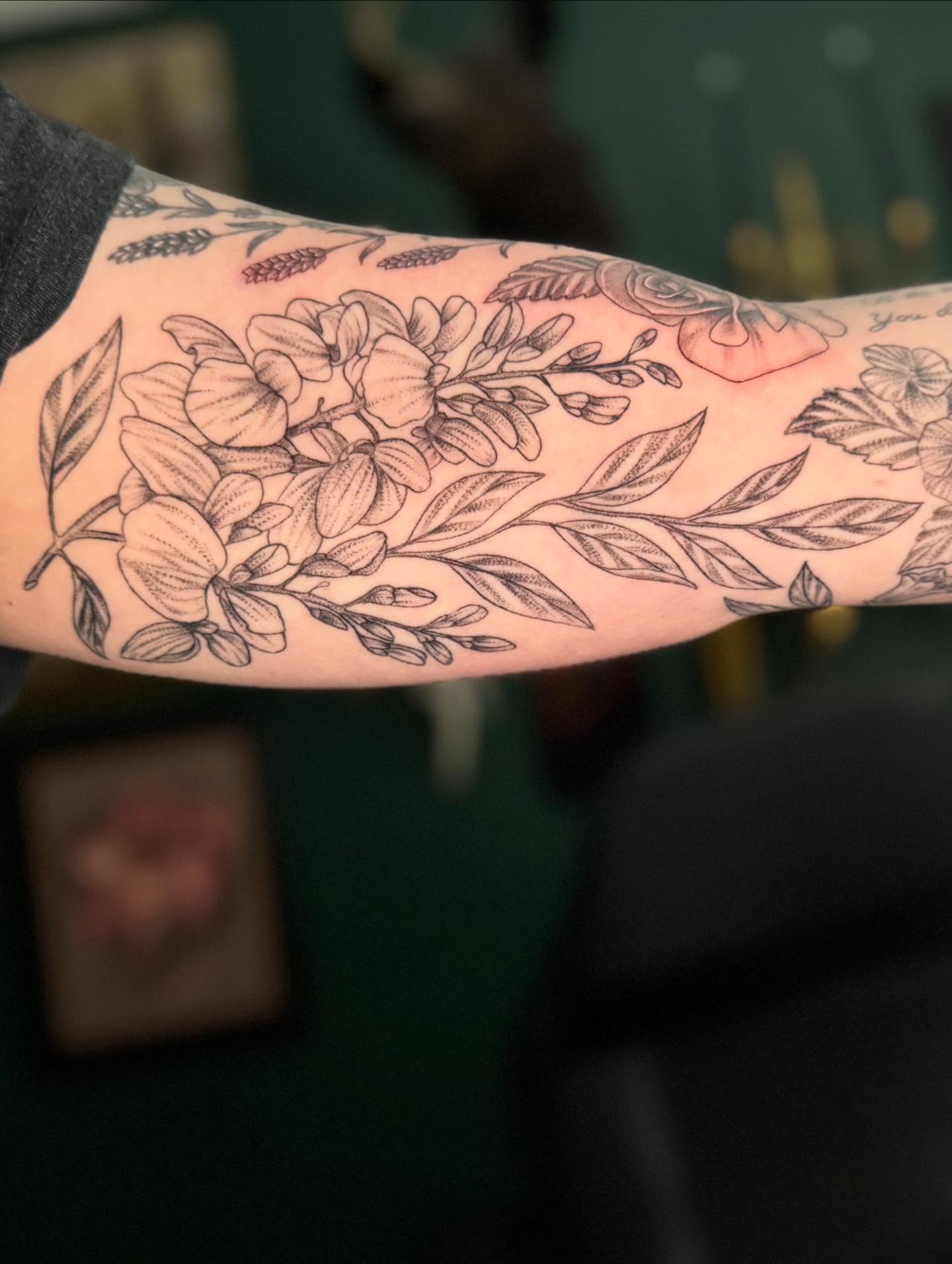 Floral bouquet black and grey tattoo on the forearm by Leslea Hipp