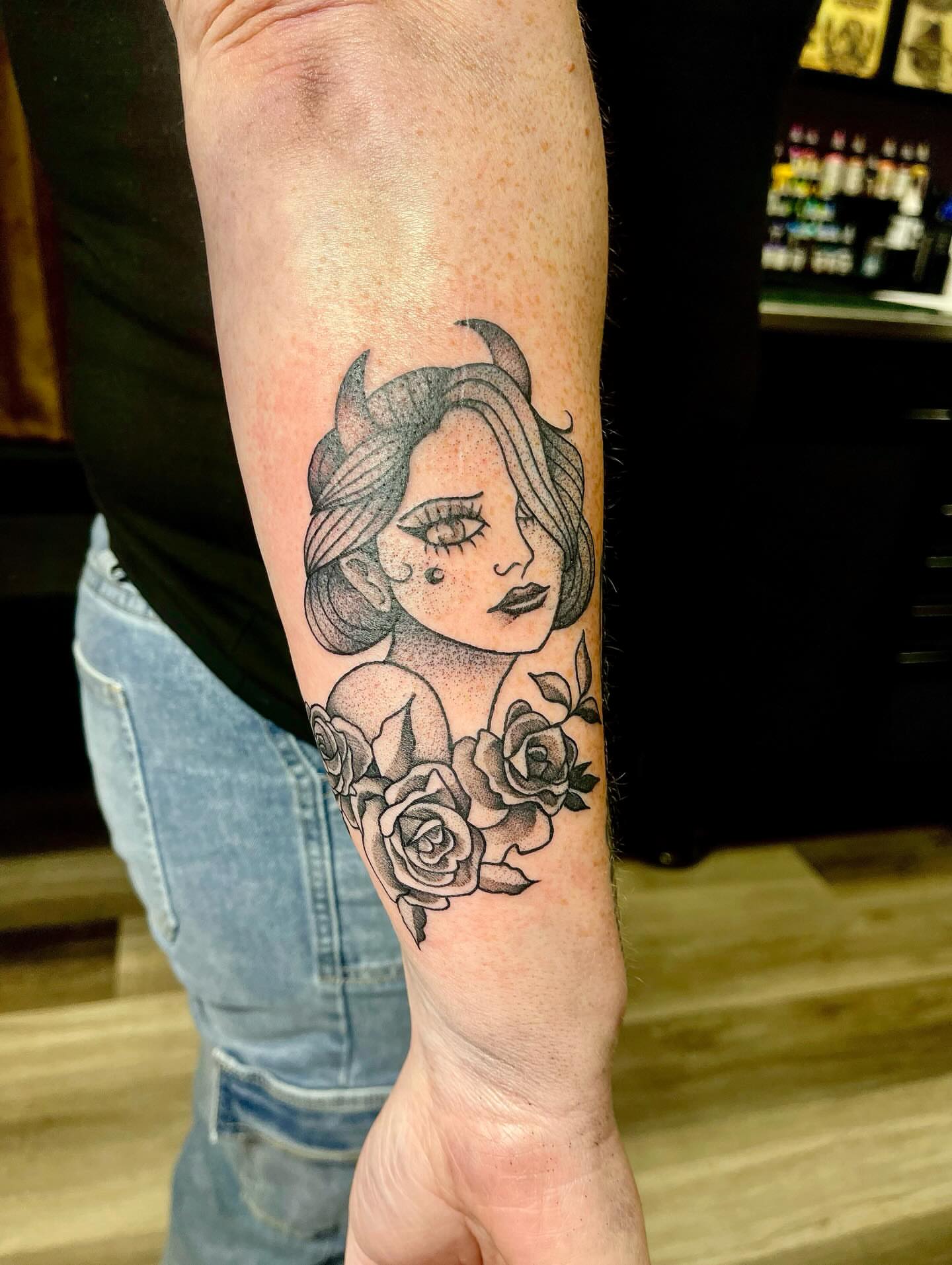 Woman with roses American traditional tattoo on the forearm by Emily