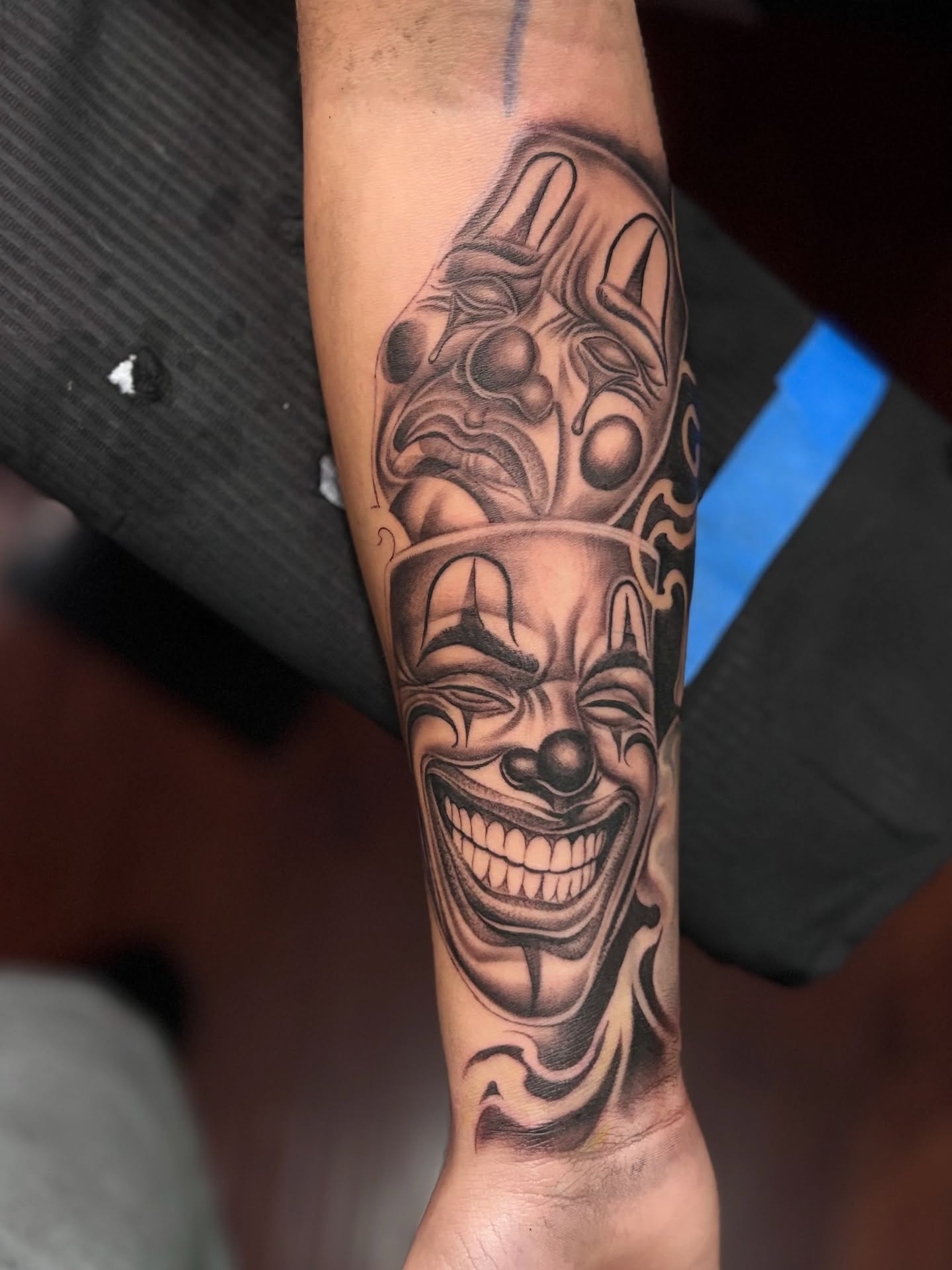 Clown face black and grey tattoo on the forearm by @tattoosbyadrian